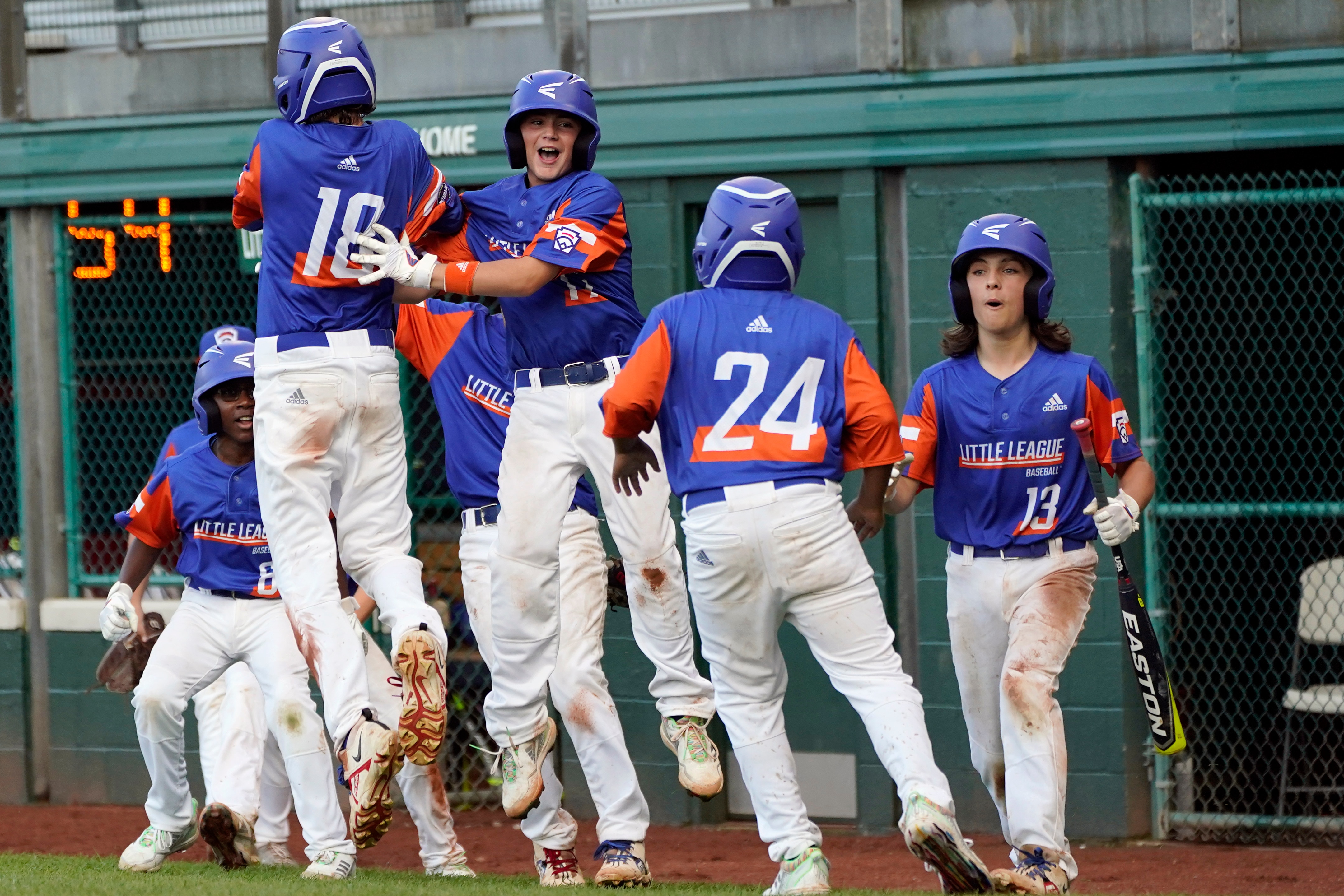 Taylor, Mich.'s Jakob Furkas (18) celebrates with Max LaForest (17) and teammates after scoring against Abilene, Texas, during the sixth inning of a baseball game at the Little League World Series tournament in South Williamsport, Pa., Monday, Aug. 23, 2021. (AP Photo/Tom E. Puskar)