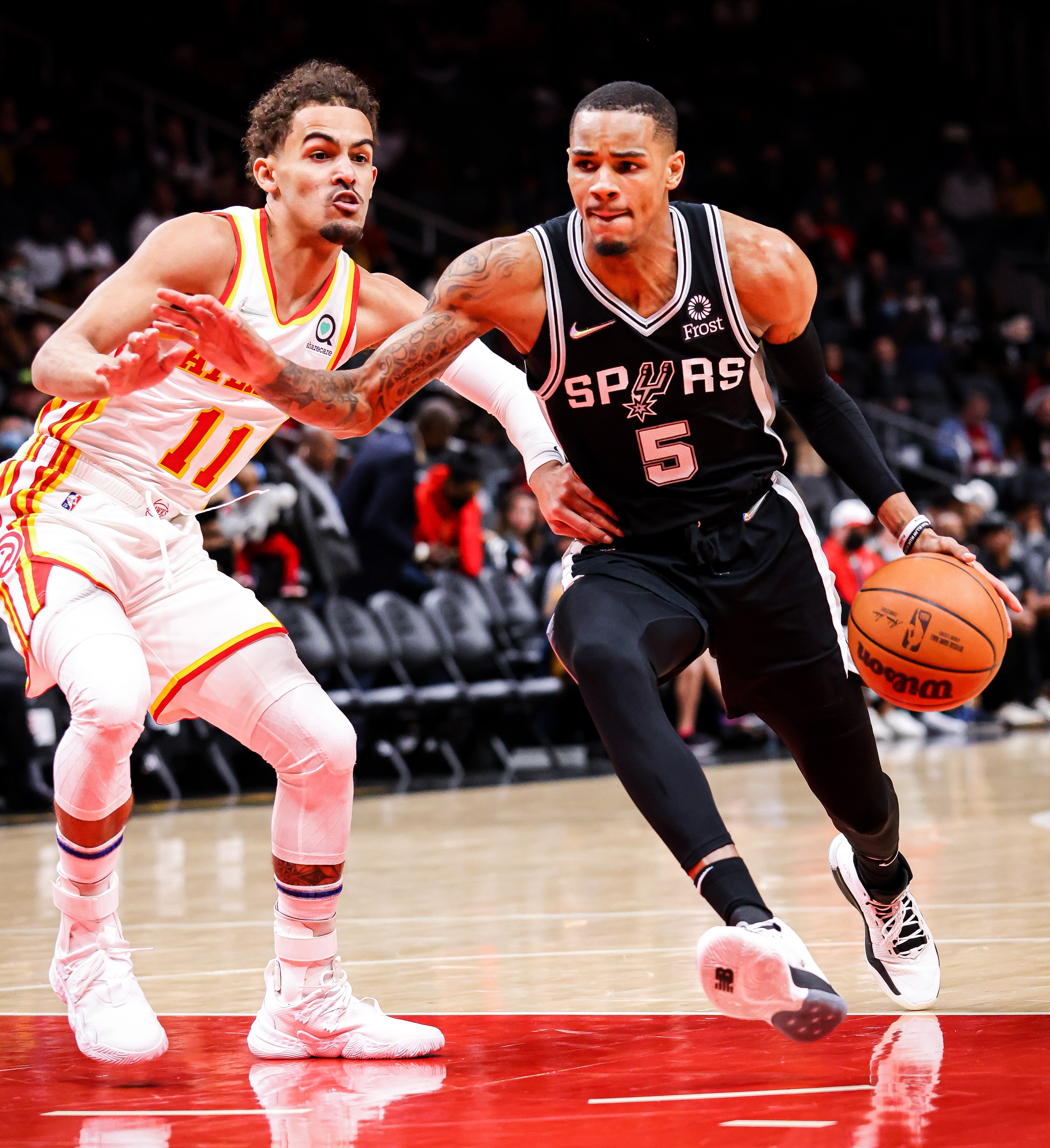 ATLANTA, GA - FEBRUARY 11: Dejounte Murray #5 of the San Antonio Spurs drives the ball past Trae Young #11 of the Atlanta Hawks during the first half of a game at State Farm Arena on February 11, 2022 in Atlanta, Georgia. NOTE TO USER: User expressly acknowledges and agrees that, by downloading and or using this photograph, User is consenting to the terms and conditions of the Getty Images License Agreement. (Photo by Casey Sykes/Getty Images)