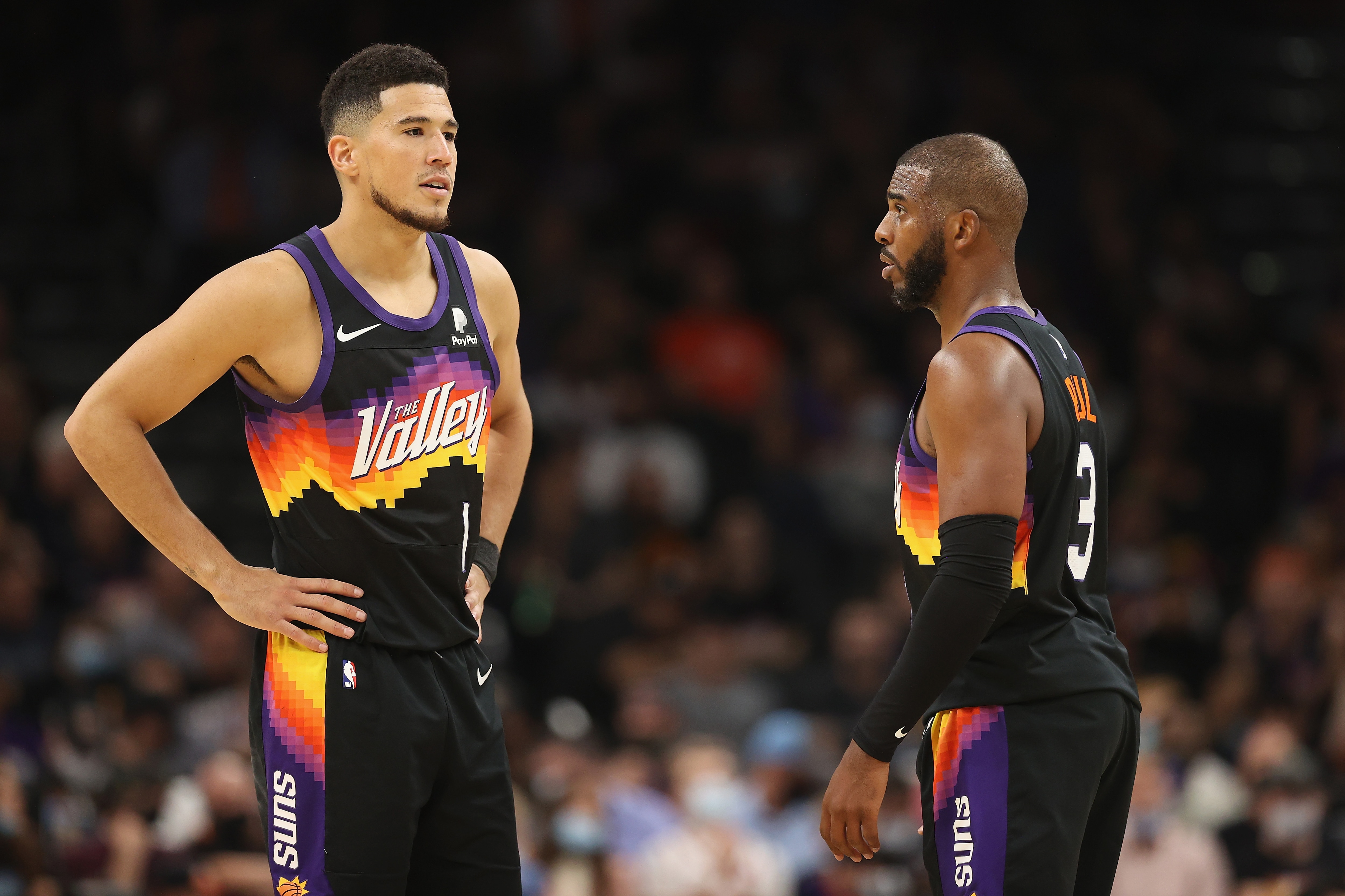 PHOENIX, ARIZONA - OCTOBER 20: Devin Booker #1 and Chris Paul #3 of the Phoenix Suns during the second half of the NBA game at Footprint Center on October 20, 2021 in Phoenix, Arizona. The Nuggets defeated the Suns 110-98. NOTE TO USER: User expressly acknowledges and agrees that, by downloading and or using this photograph, User is consenting to the terms and conditions of the Getty Images License Agreement. (Photo by Christian Petersen/Getty Images)