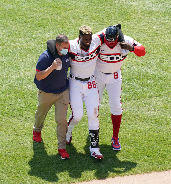 CHICAGO, ILLINOIS - MAY 02: Luis Robert #88 of the Chicago White Sox is helped off the field after he gets injured during the first inning of a game against the Cleveland Indians at Guaranteed Rate Field on May 02, 2021 in Chicago, Illinois. (Photo by Nuccio DiNuzzo/Getty Images)