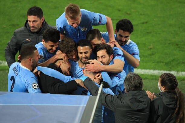 Manchester City's English midfielder Phil Foden (front R) celebrates scoring the 1-2 goal with his team-mates and Manchester City's Spanish manager Pep Guardiola during the UEFA Champions League quarter-final second leg football match between BVB Borussia Dortmund and Manchester City in Dortmund, western Germany, on April 14, 2021. (Photo by WOLFGANG RATTAY / various sources / AFP) (Photo by WOLFGANG RATTAY/AFP via Getty Images)