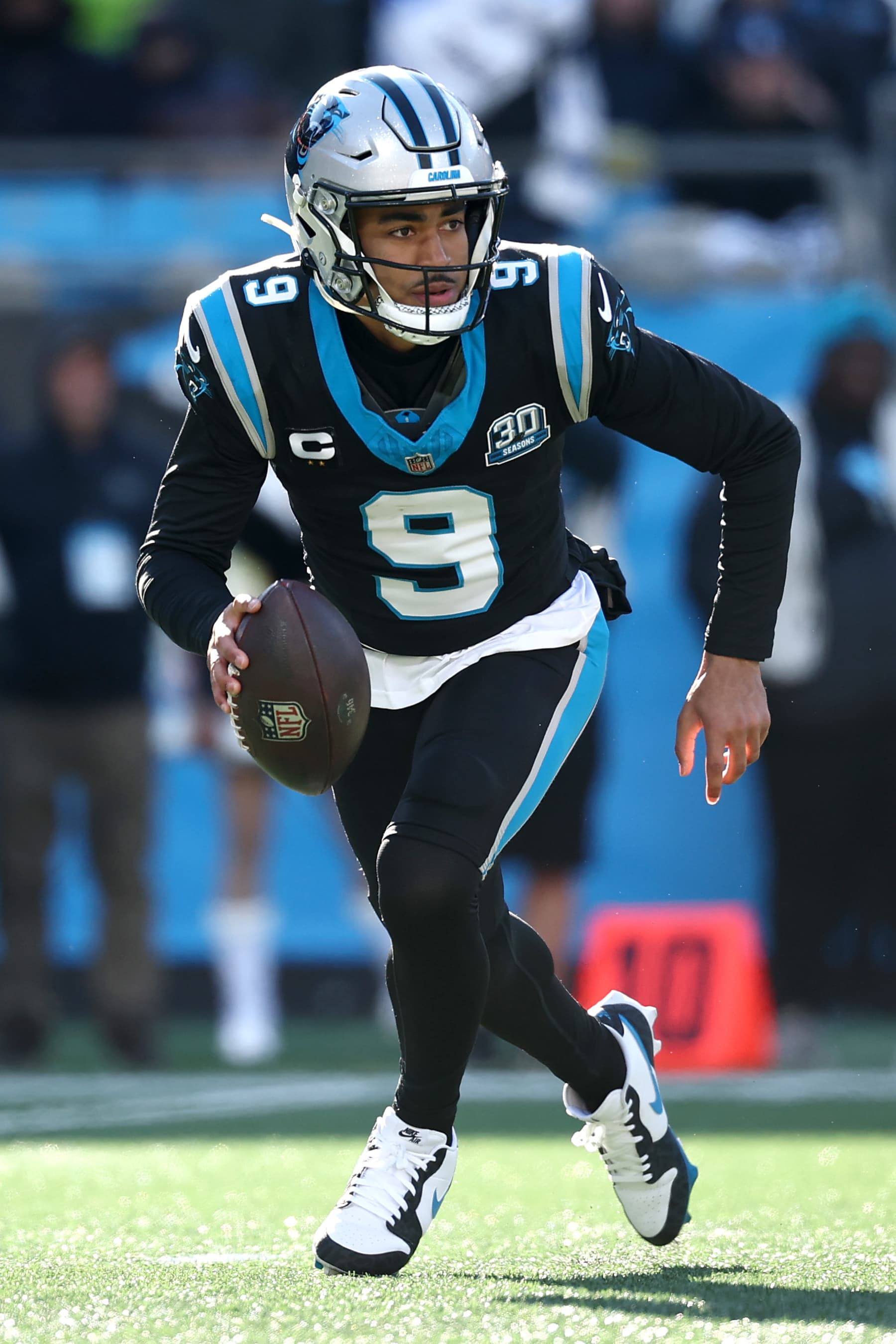 CHARLOTTE, NORTH CAROLINA - DECEMBER 22: Bryce Young #9 of the Carolina Panthers scrambles outside the pocket during the first half of the game against the Arizona Cardinals at Bank of America Stadium on December 22, 2024 in Charlotte, North Carolina. (Photo by Jared C. Tilton/Getty Images)