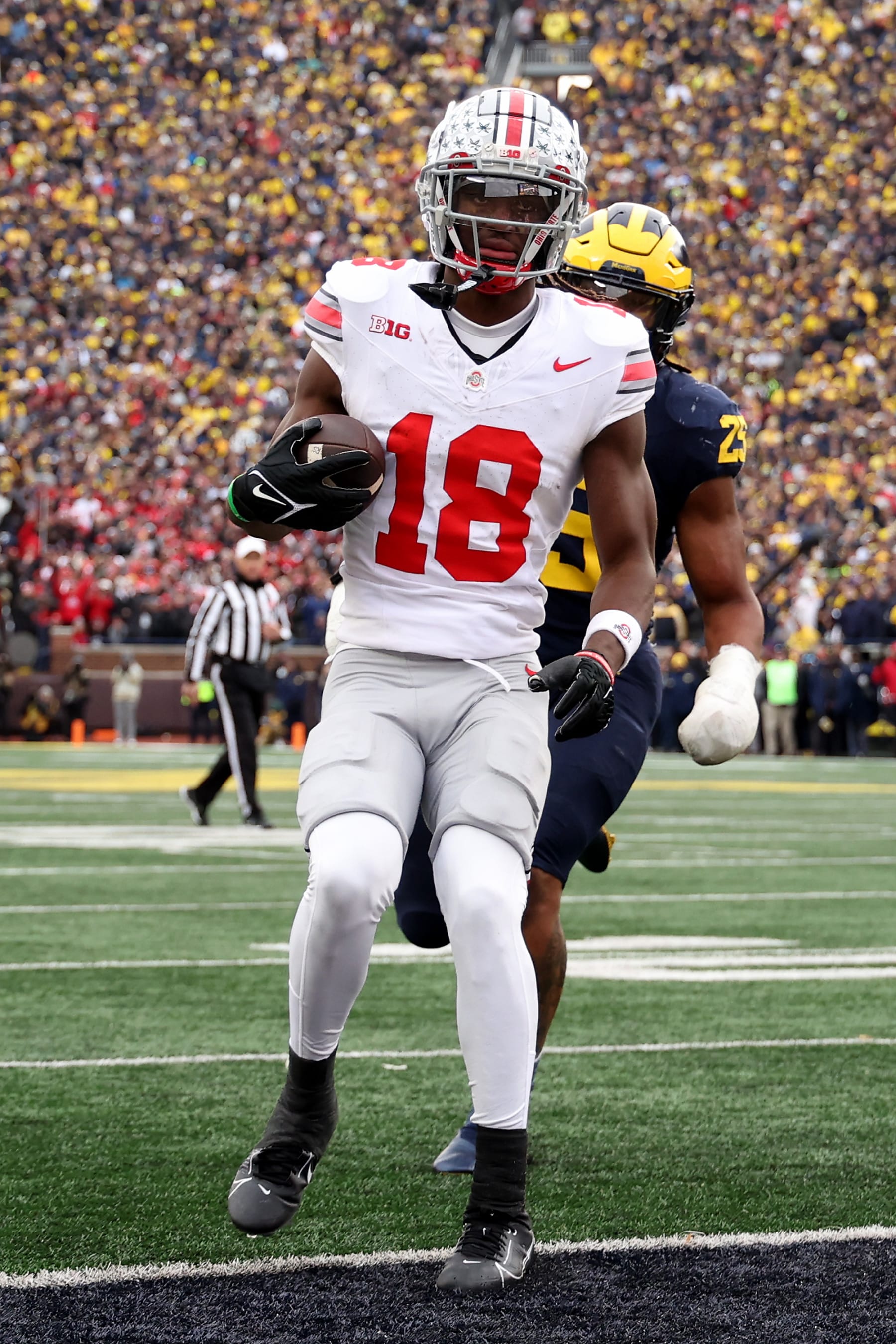 ANN ARBOR, MICHIGAN - NOVEMBER 25: Marvin Harrison Jr. #18 of the Ohio State Buckeyes scores a touchdown against Junior Colson #25 of the Michigan Wolverines during the fourth quarter in the game at Michigan Stadium on November 25, 2023 in Ann Arbor, Michigan. (Photo by Ezra Shaw/Getty Images)