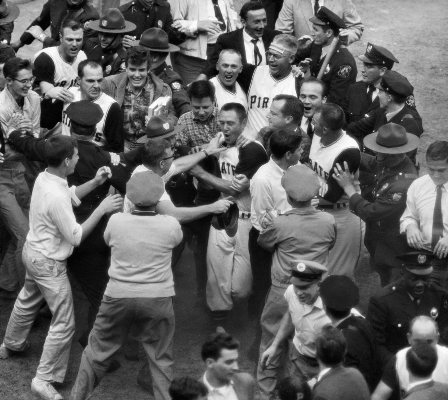 (Original Caption) 10/13/1960-Forbes Field, Pittsburgh, PA: Fans and players mob Pirates'Bill Mazeroski after his ninth inning homer that gave the Pirates the 1960World Series. One fan has his hans around Mazeroski while another attempts to grab him.