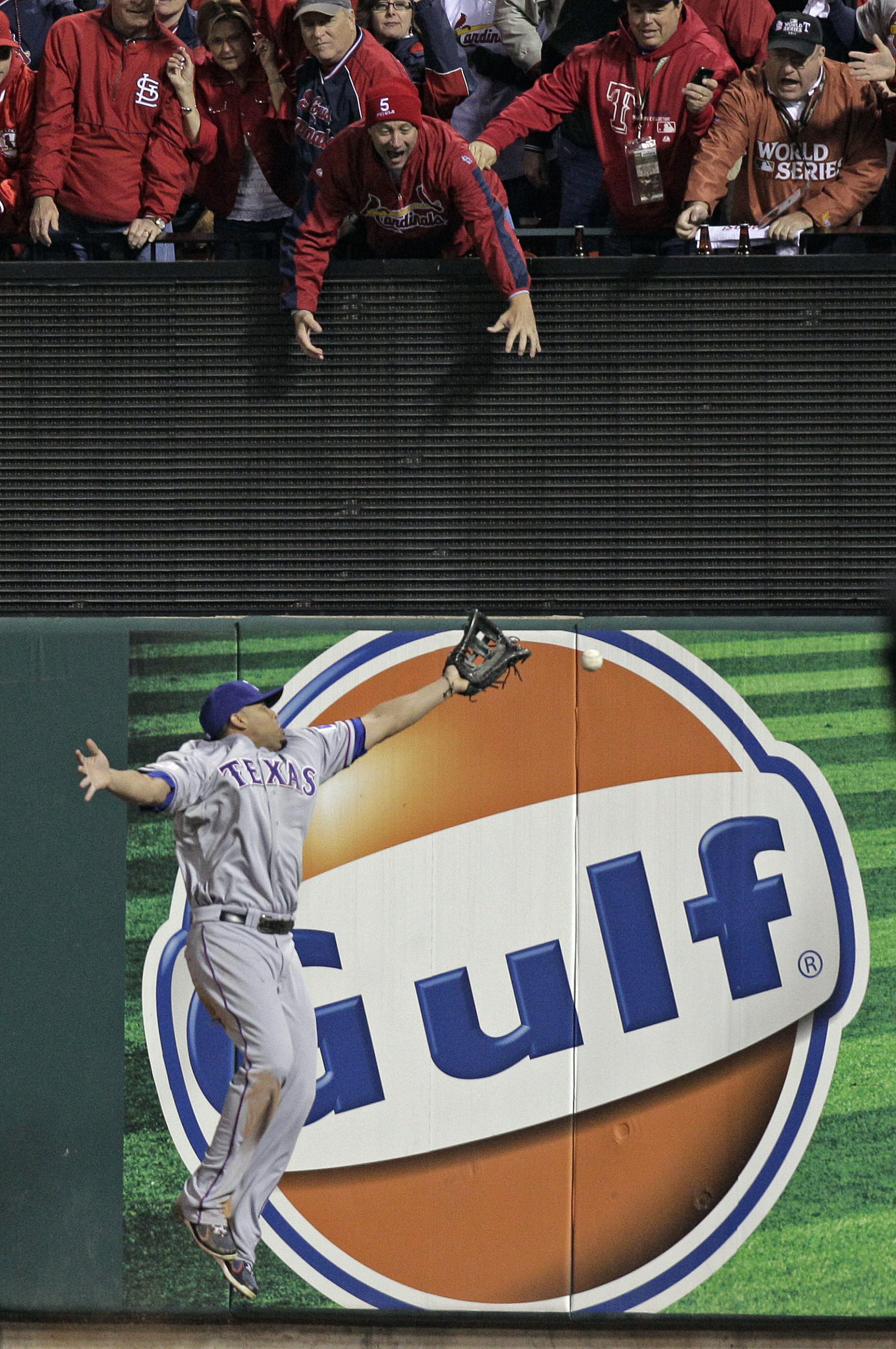 Texas Rangers' Nelson Cruz can't come up with a triple off the bat of St. Louis Cardinals' David Freese during the ninth inning of Game 6 of baseball's World Series Thursday, Oct. 27, 2011, in St. Louis. (AP Photo/Charlie Riedel)