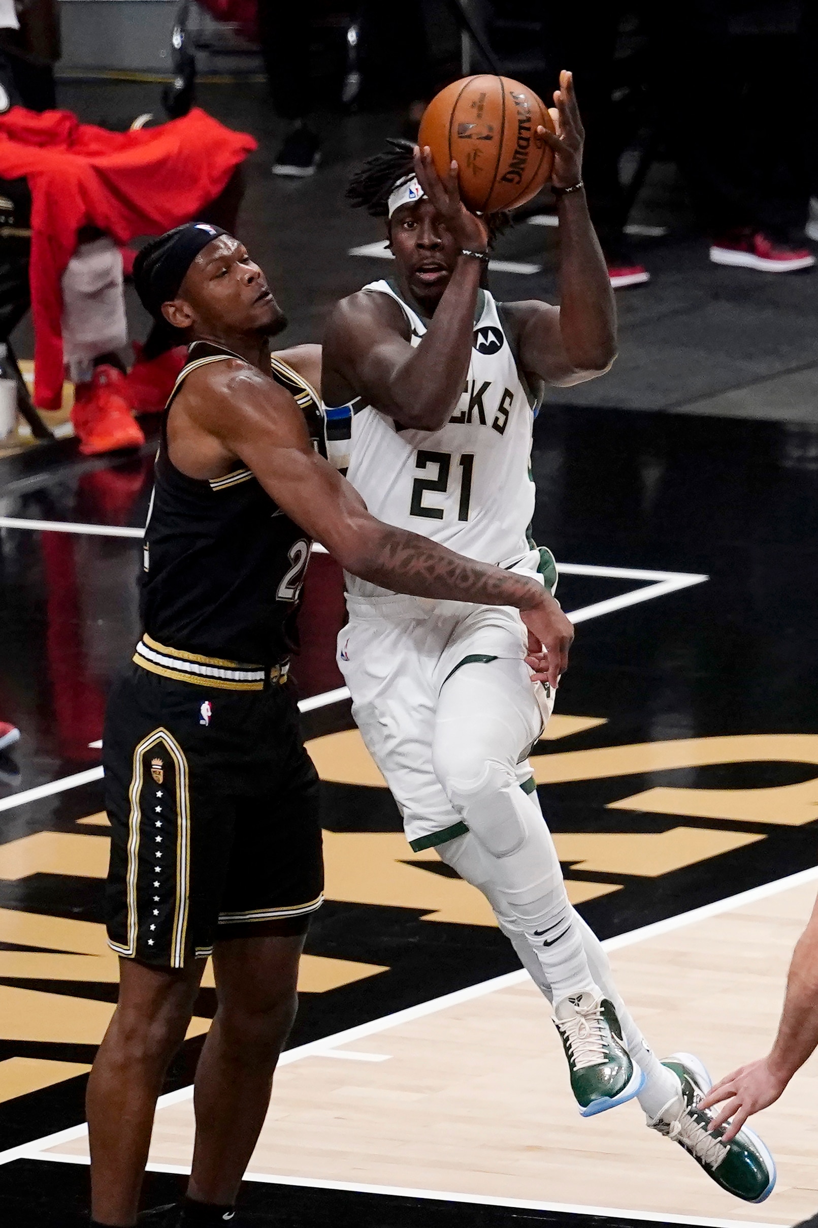 Milwaukee Bucks guard Jrue Holiday (21) drives against Atlanta Hawks forward Cam Reddish (22) during the first half of Game 6 of the Eastern Conference finals in the NBA basketball playoffs Saturday, July 3, 2021, in Atlanta. (AP Photo/John Bazemore)