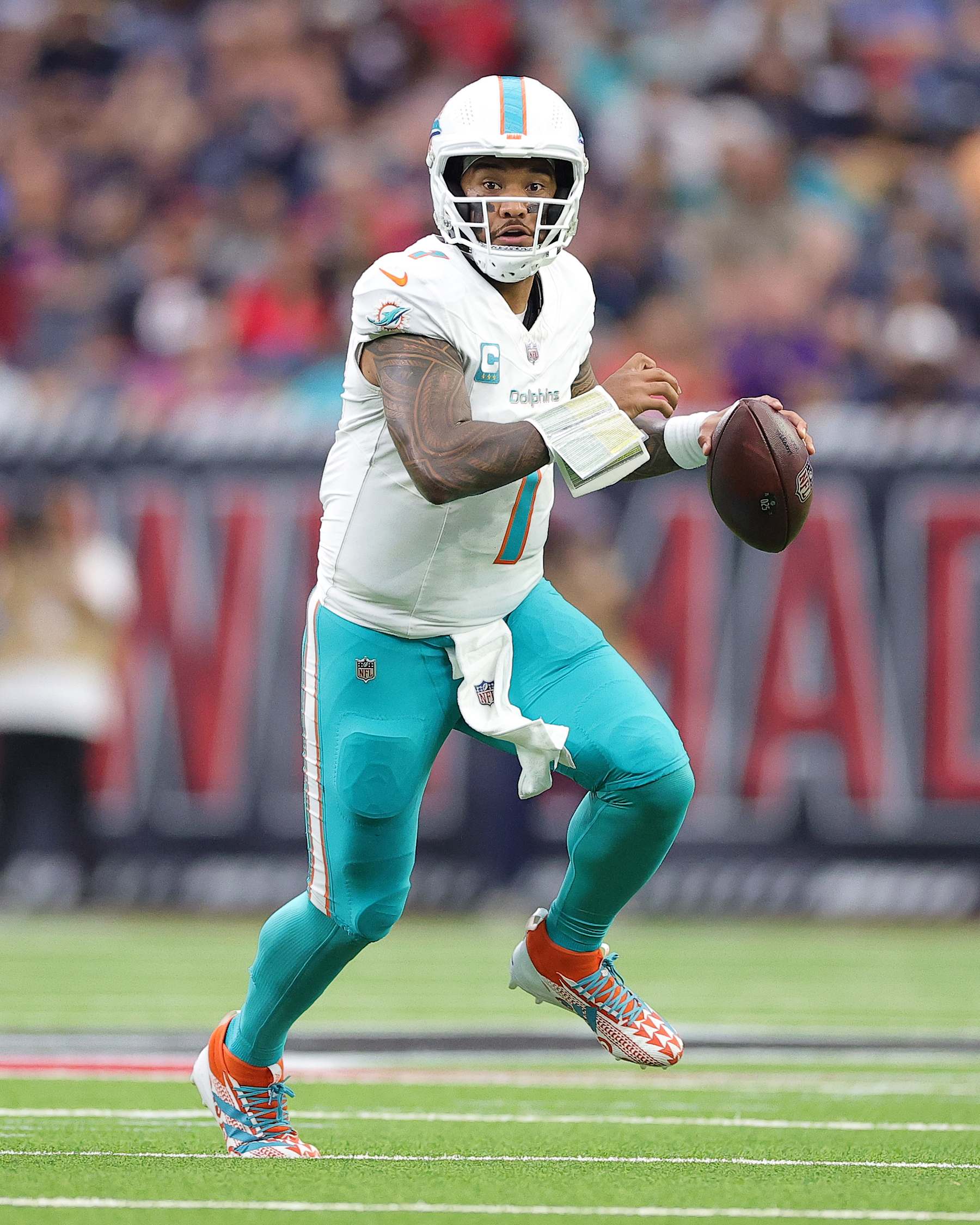 HOUSTON, TEXAS - DECEMBER 15: Tua Tagovailoa #1 of the Miami Dolphins runs the ball against the Houston Texans during the second quarter at NRG Stadium on December 15, 2024 in Houston, Texas. (Photo by Alex Slitz/Getty Images)