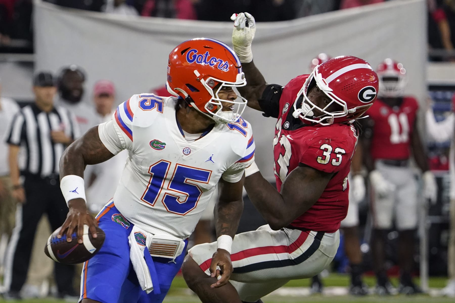 Florida quarterback Anthony Richardson (15) dodges a tackle by Georgia linebacker Robert Beal Jr. (33) during the second half of an NCAA college football game Saturday, Oct. 29, 2022, in Jacksonville, Fla. (AP Photo/John Raoux)