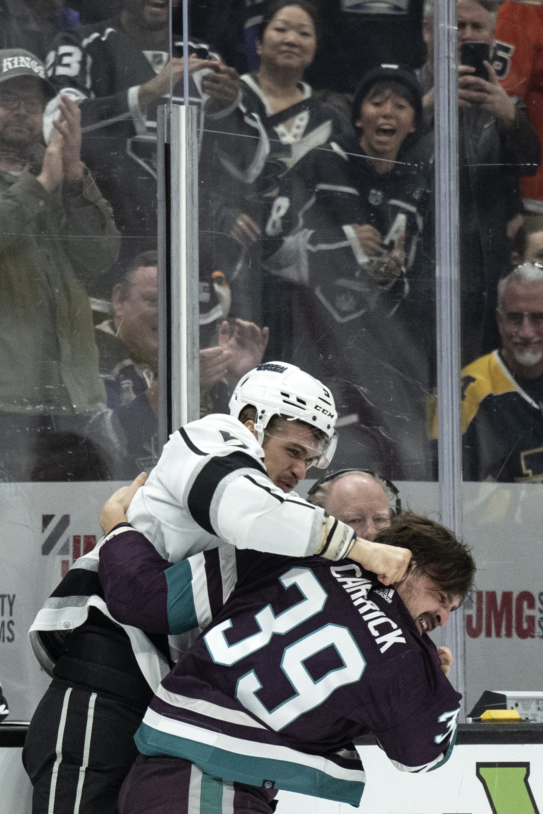 Los Angeles Kings defenseman Andreas Englund (5) and Anaheim Ducks center Sam Carrick (39) fight during the second period of an NHL hockey game, Friday, Nov. 24, 2023, in Anaheim, Calif. (AP Photo/Kyusung Gong)
