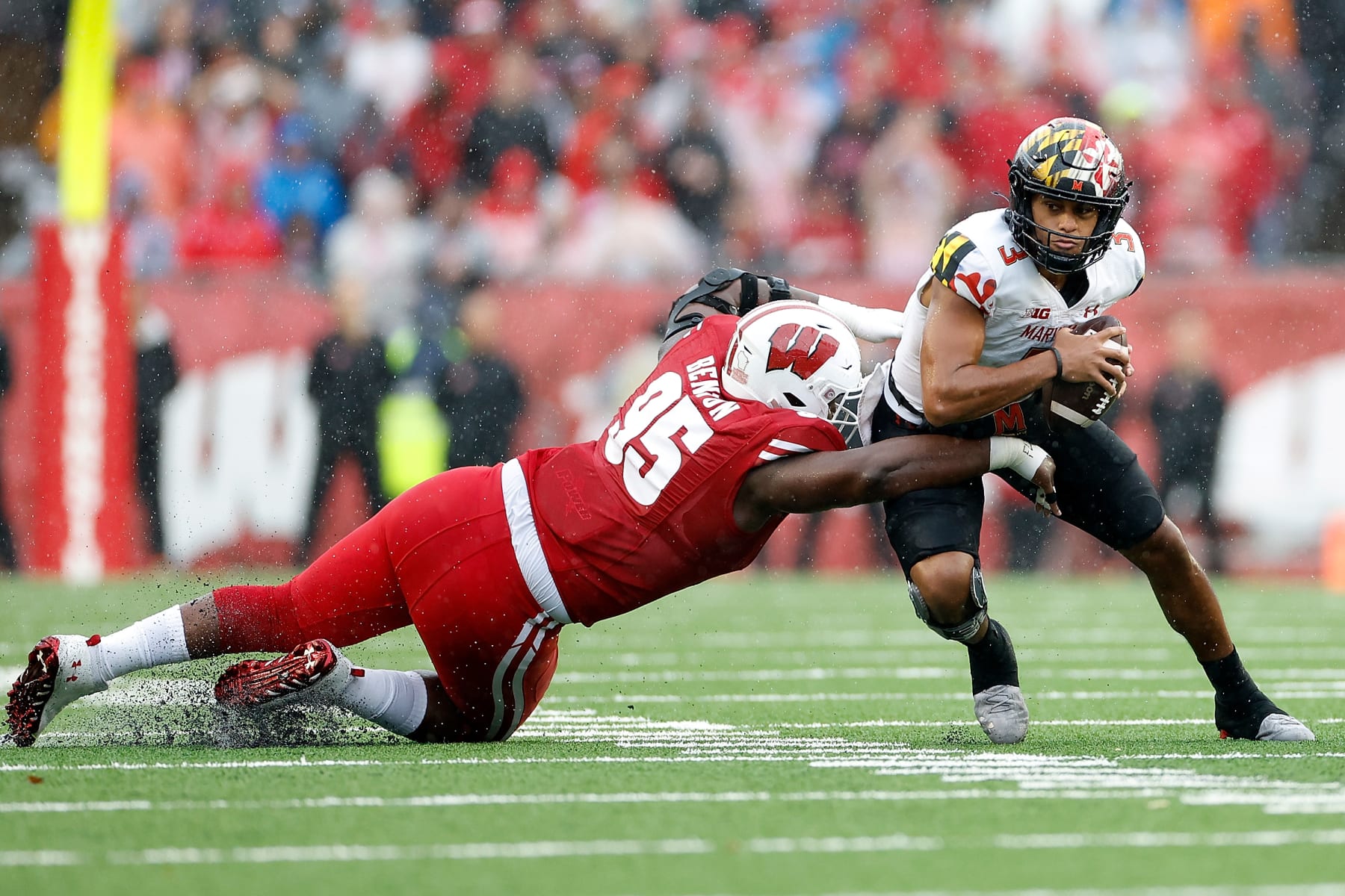 MADISON, WISCONSIN - NOVEMBER 05: Keeanu Benton #95 of the Wisconsin Badgers sacks Taulia Tagovailoa #3 of the Maryland Terrapins in the first quarter against the Wisconsin Badgers at Camp Randall Stadium on November 05, 2022 in Madison, Wisconsin. (Photo by John Fisher/Getty Images)