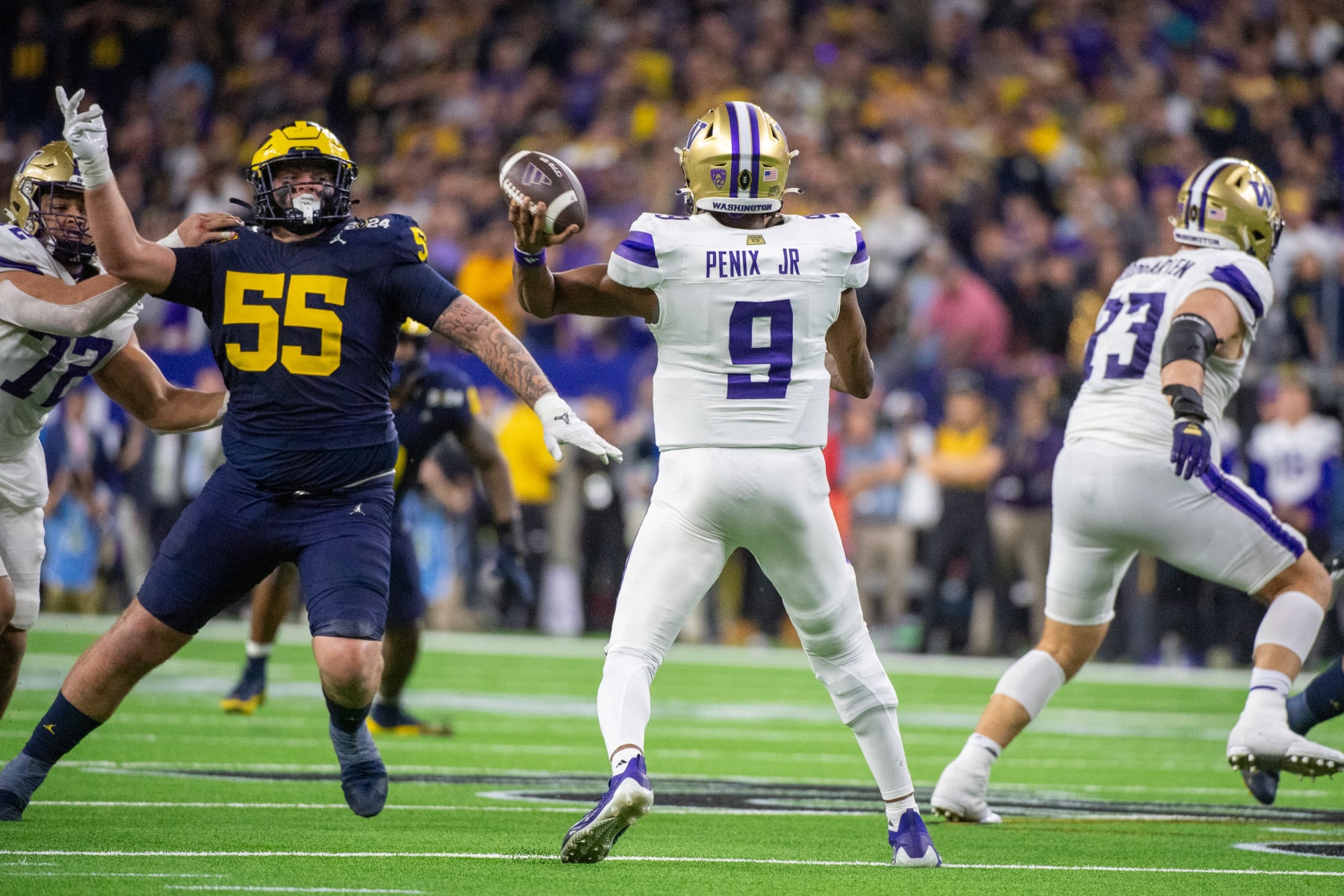 HOUSTON, TEXAS - JANUARY 08: Michael Penix Jr. #9 of the Washington Huskies looks to throw the ball downfield against Mason Graham #55 of the Michigan Wolverines during the first half of the 2024 CFP National Championship game at NRG Stadium on January 08, 2024 in Houston, Texas.  (Photo by Aaron J. Thornton/Getty Images)