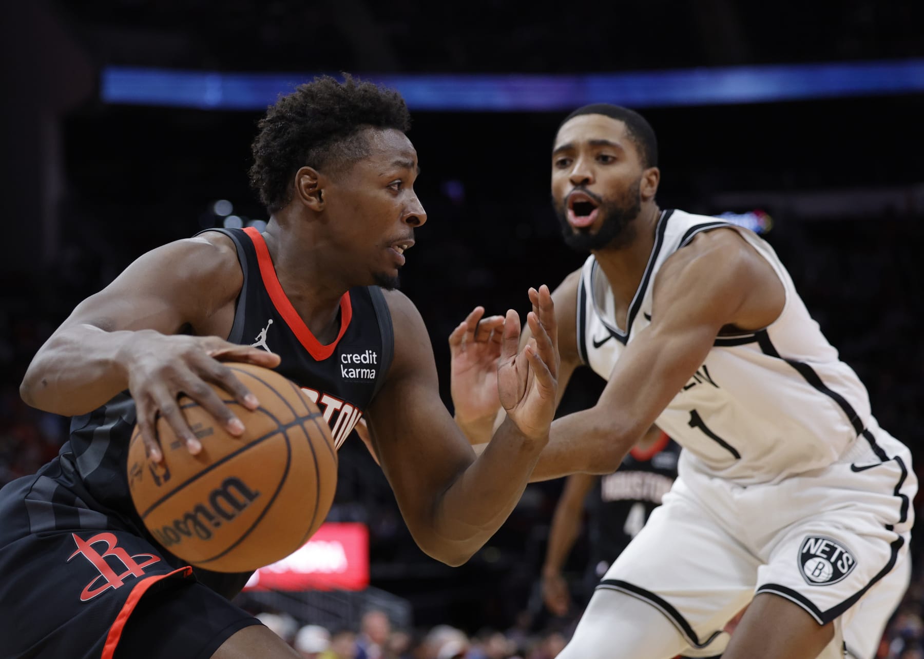 HOUSTON, TEXAS - JANUARY 03: Jae'Sean Tate #8 of the Houston Rockets controls the ball head of Mikal Bridges #1 of the Brooklyn Nets during the first half at Toyota Center on January 03, 2024 in Houston, Texas. NOTE TO USER: User expressly acknowledges and agrees that, by downloading and or using this photograph, User is consenting to the terms and conditions of the Getty Images License Agreement.  (Photo by Carmen Mandato/Getty Images)