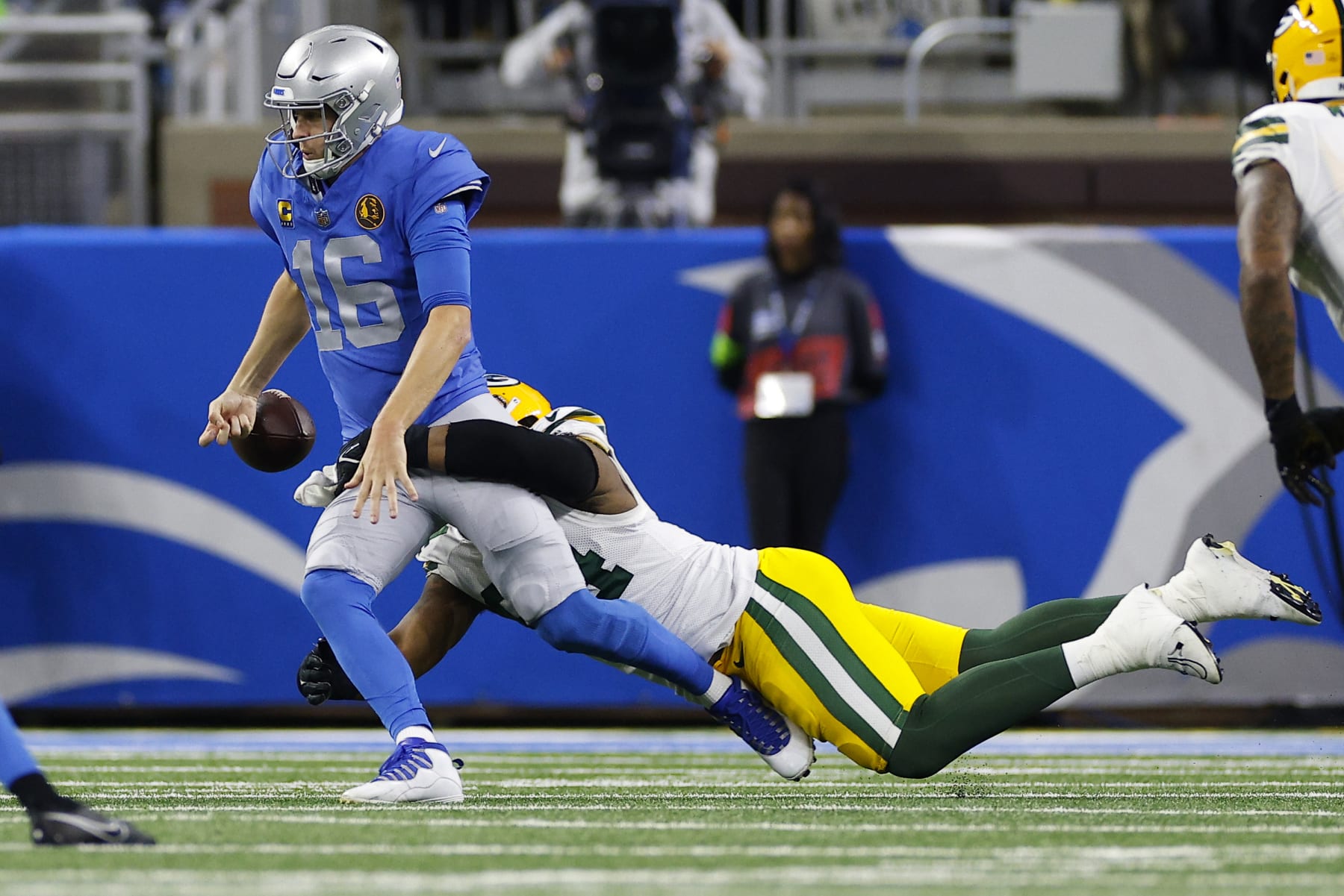 DETROIT, MICHIGAN - NOVEMBER 23: Karl Brooks #94 of the Green Bay Packers forces a fumble on Jared Goff #16 of the Detroit Lions during the first quarter of the game at Ford Field on November 23, 2023 in Detroit, Michigan. (Photo by Mike Mulholland/Getty Images)