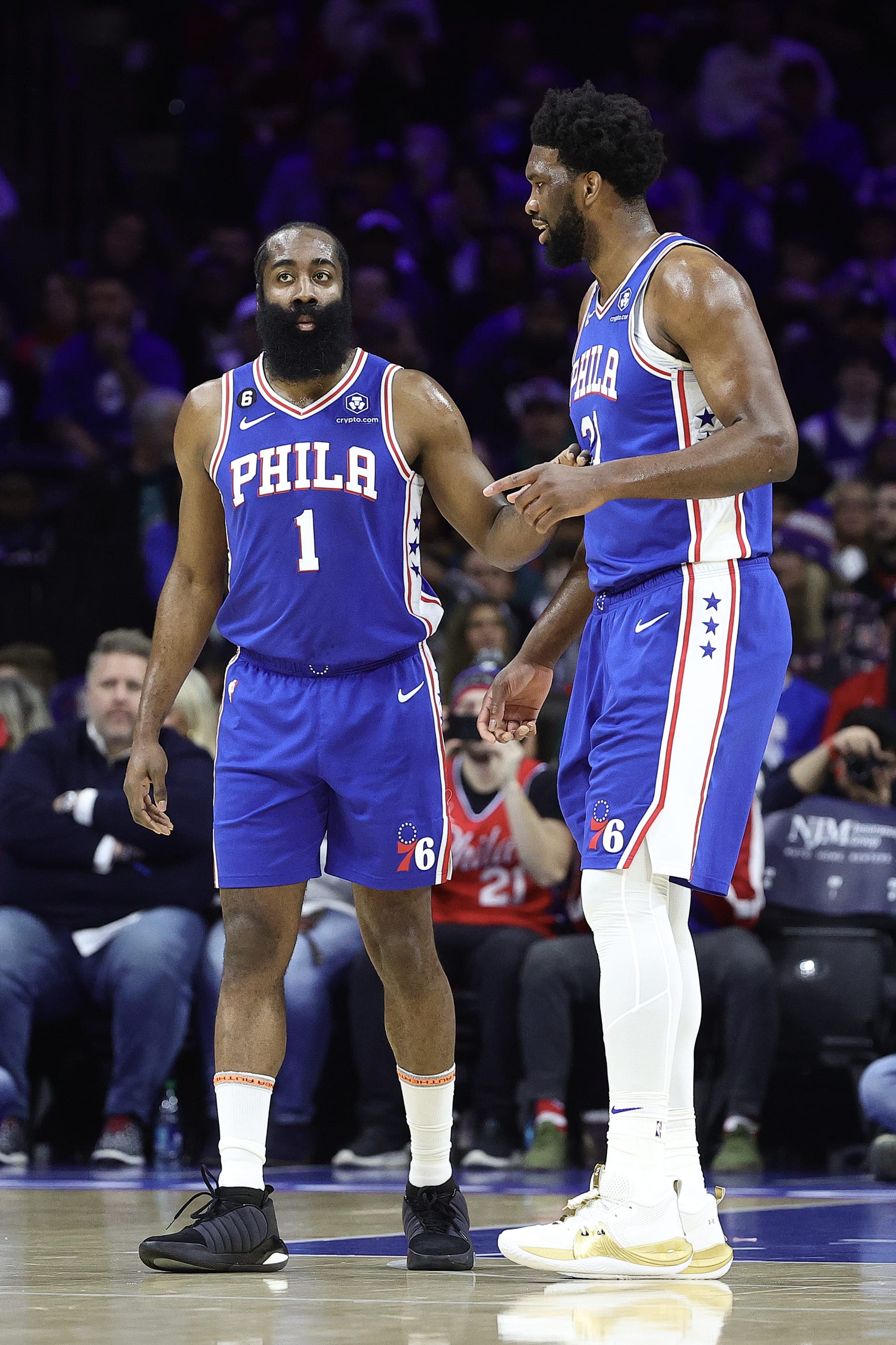 PHILADELPHIA, PENNSYLVANIA - JANUARY 30: James Harden #1 and Joel Embiid #21 of the Philadelphia 76ers speak during the first quarter against the Orlando Magic at Wells Fargo Center on January 30, 2023 in Philadelphia, Pennsylvania. NOTE TO USER: User expressly acknowledges and agrees that, by downloading and or using this photograph, User is consenting to the terms and conditions of the Getty Images License Agreement. (Photo by Tim Nwachukwu/Getty Images)