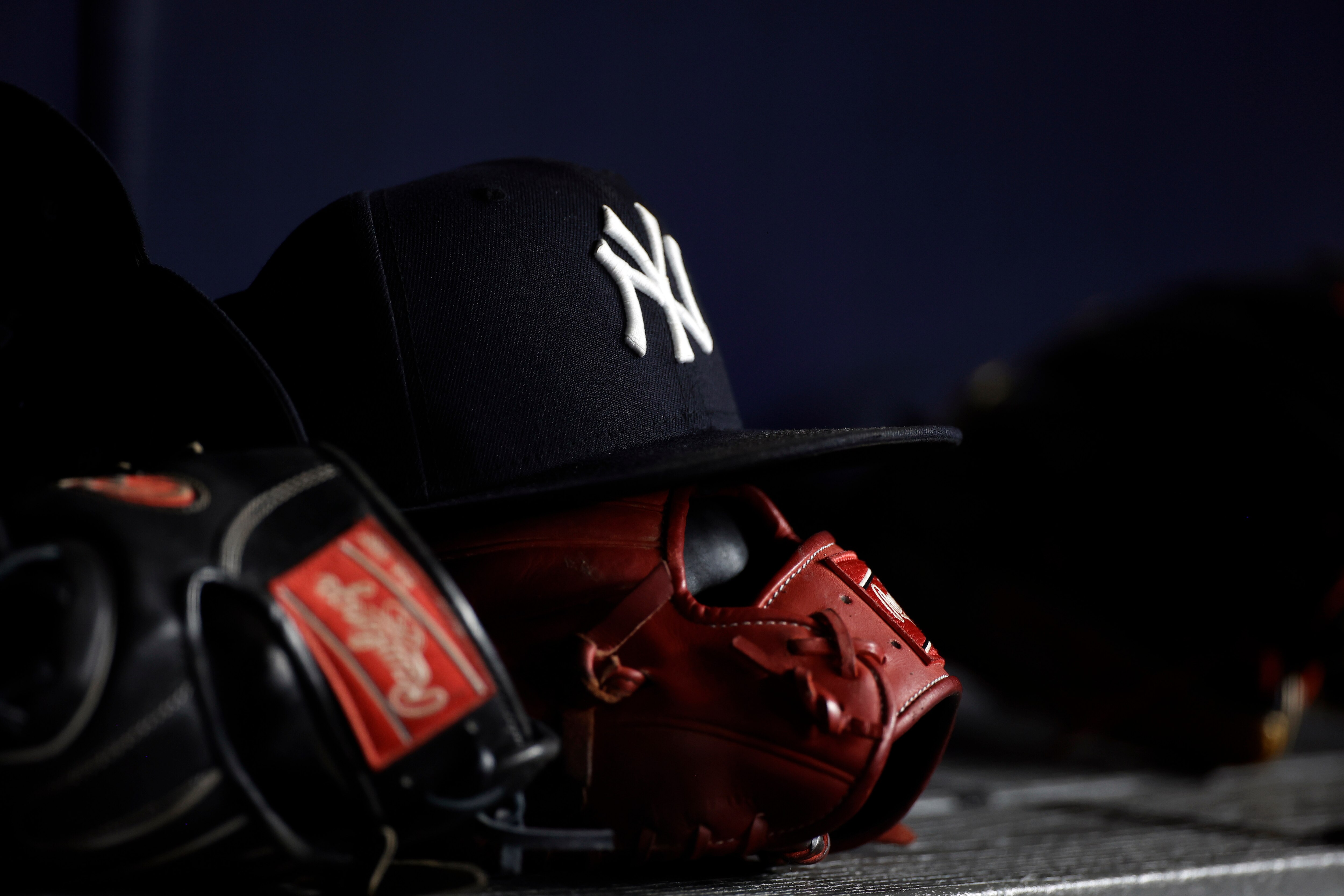 NEW YORK, NY - JUNE 6: A New York Yankees baseball hat sits on top of a glove in the Yankee dugout against the Boston Red Sox during the eighth inning at Yankee Stadium on June 6, 2021 in the Bronx borough of New York City. (Photo by Adam Hunger/Getty Images)