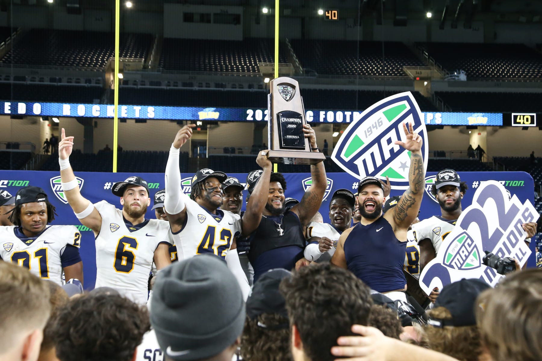 DETROIT, MI - DECEMBER 03:  Toledo players celebrate with the championship trophy during the post-game awards ceremony following the Mid-American Conference college football championship game between the Toledo Rockets and the Ohio Bobcats on December 3, 2022 at Ford Field in Detroit, Michigan.  (Photo by Scott W. Grau/Icon Sportswire via Getty Images)