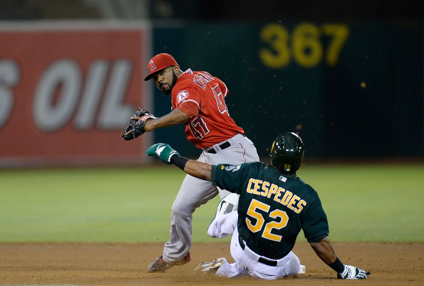 OAKLAND, CA - SEPTEMBER 16:  Howie Kendrick #47 of the Los Angeles Angels of Anaheim gets his throw off over the sliding Yoenis Cespedes #52 of the Oakland Athletics but not in time to complete the double-play during the fourth inning at O.co Coliseum on September 16, 2013 in Oakland, California.  (Photo by Thearon W. Henderson/Getty Images) 