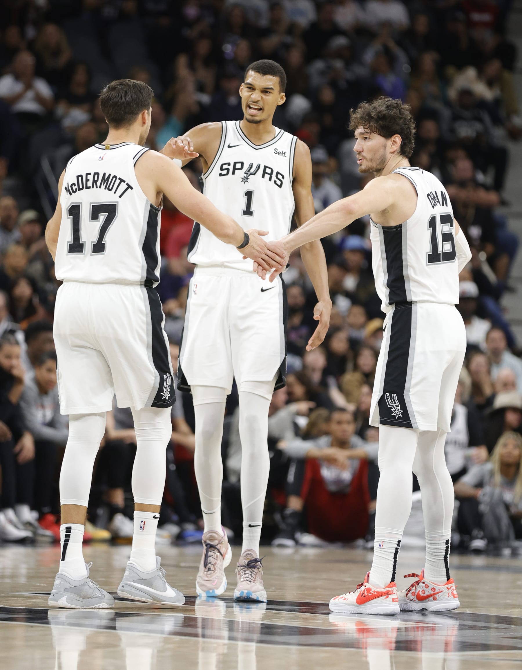 SAN ANTONIO, TX - NOVEMBER 12:  Victor Wembanyama #1 of the San Antonio Spurs and Cedi Osman #16  congratulate Doug McDermott #17 after he hit a three against the Miami Heatin the second half at Frost Bank Center on November  12, 2023 in San Antonio, Texas. NOTE TO USER: User expressly acknowledges and agrees that, by downloading and or using this photograph, User is consenting to terms and conditions of the Getty Images License Agreement. (Photo by Ronald Cortes/Getty Images)