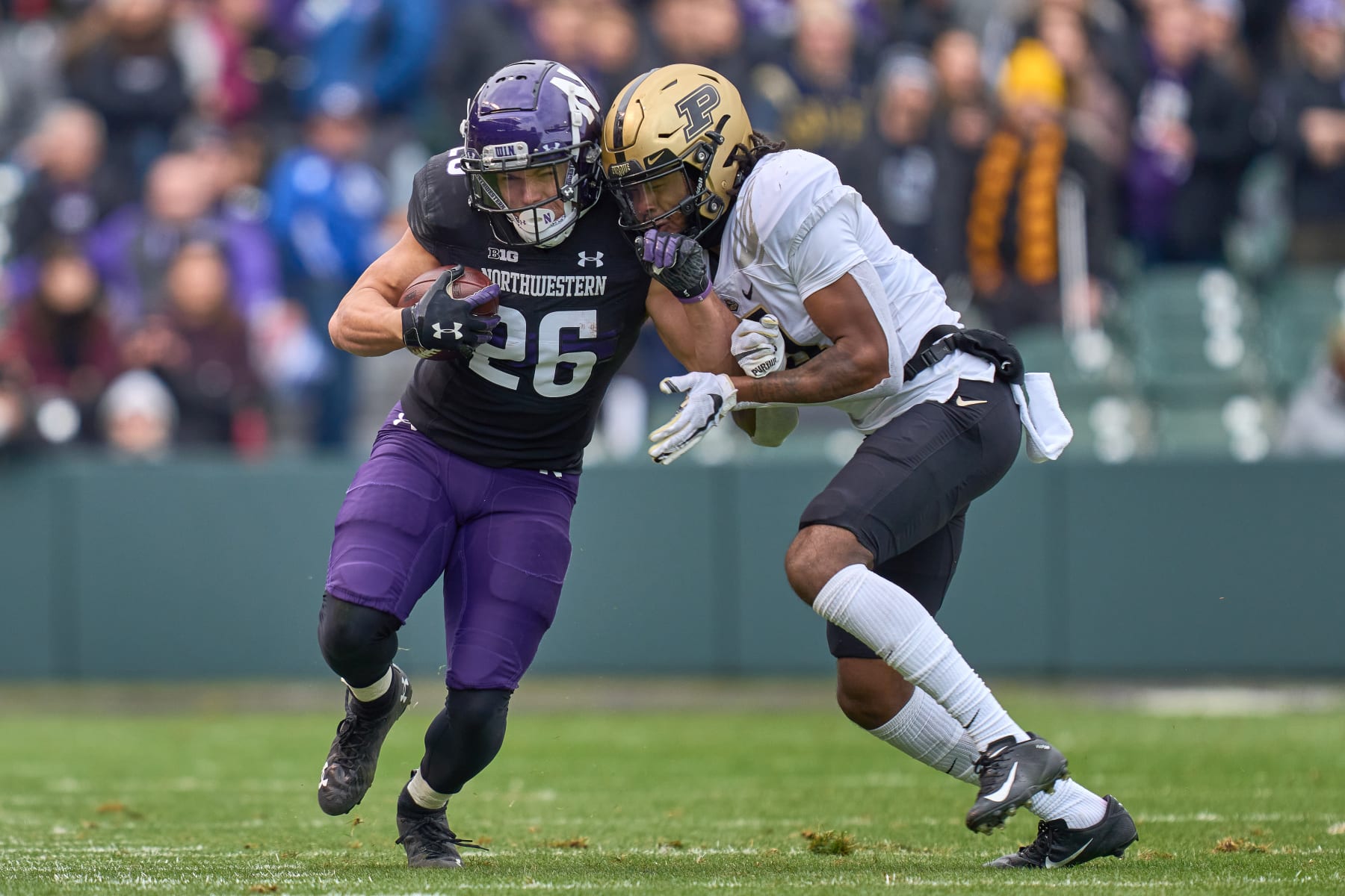 CHICAGO, IL - NOVEMBER 20: Northwestern Wildcats running back Evan Hull (26) battles with Purdue Boilermakers safety Marvin Grant (4) during a game between the Northwestern Wildcats and the Purdue Boilermakers on November 20, 2021 at Wrigley Field in Chicago, IL. (Photo by Robin Alam/Icon Sportswire via Getty Images)