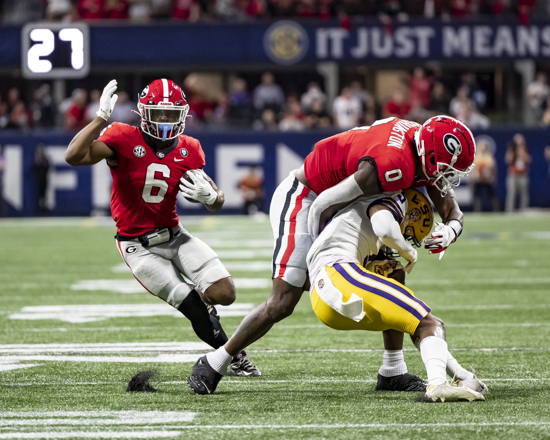 ATLANTA, GA - DECEMBER 3: Kenny McIntosh #6 runs with the ball while Darnell Washington #0 of the Georgia Bulldogs blocks Jay Ward #5 of the LSU Tigers during a game between LSU Tigers and Georgia Bulldogs at Mercedes-Benz Stadium on December 3, 2022 in Atlanta, Georgia. (Photo by Steve Limentani/ISI Photos/Getty Images)