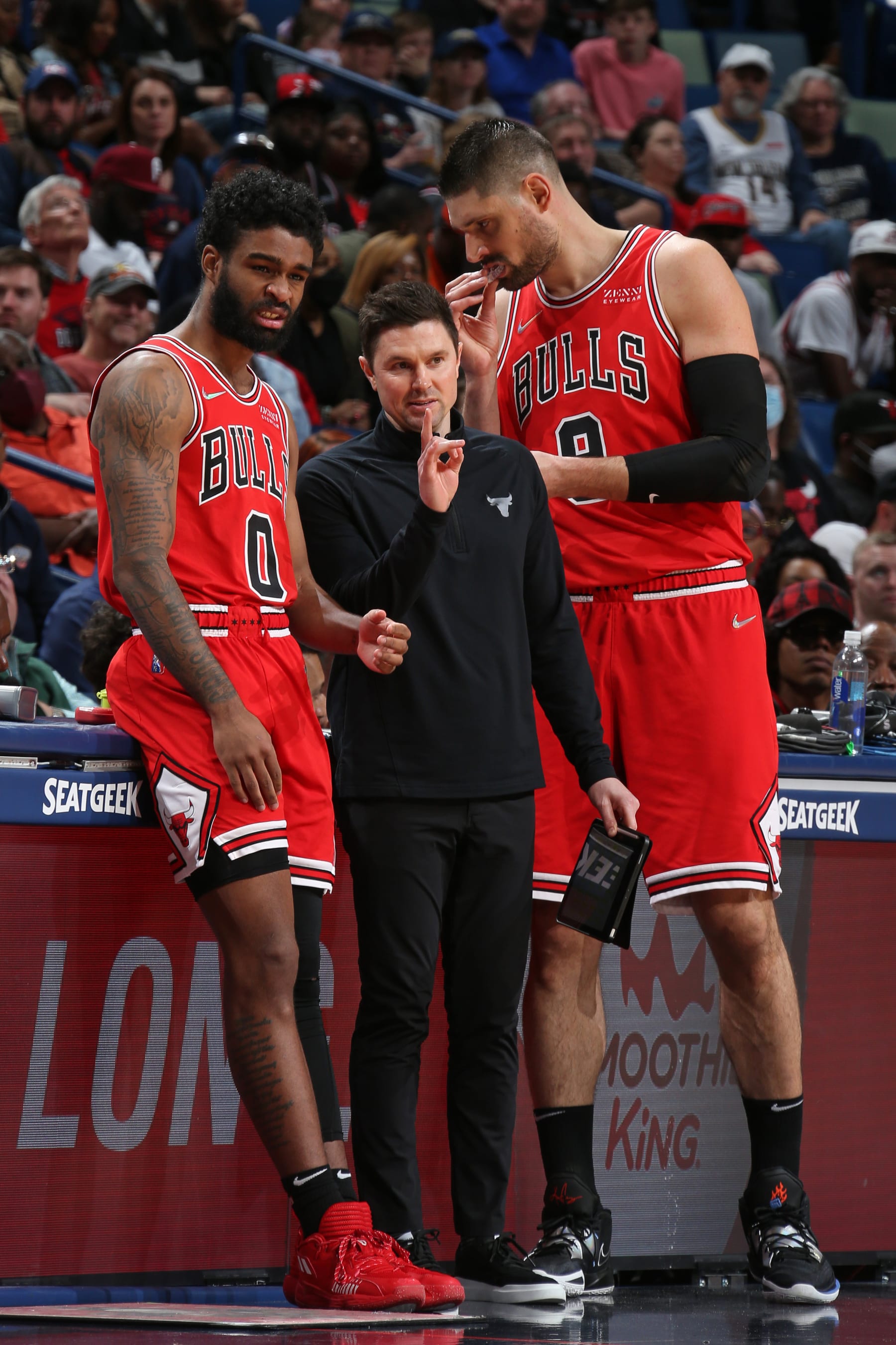 NEW ORLEANS, LA - MARCH 24: Coby White #0 and Nikola Vucevic #9 of the Chicago Bulls talk with Assistant Coach Josh Longstaff of the Chicago Bulls during the game against the New Orleans Pelicans on March 24, 2022 at the Smoothie King Center in New Orleans, Louisiana. NOTE TO USER: User expressly acknowledges and agrees that, by downloading and or using this Photograph, user is consenting to the terms and conditions of the Getty Images License Agreement. Mandatory Copyright Notice: Copyright 2022 NBAE (Photo by Layne Murdoch Jr./NBAE via Getty Images)