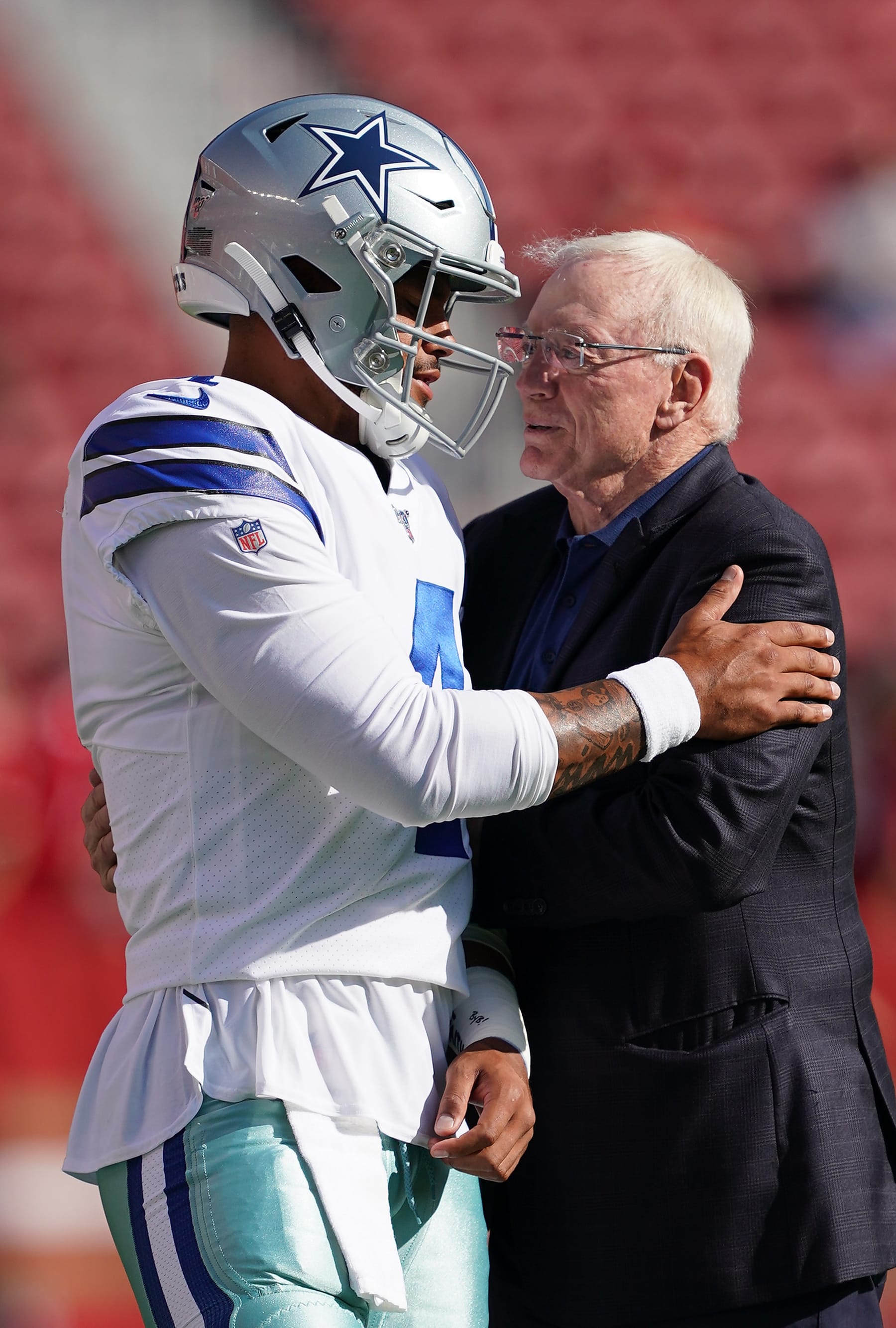SANTA CLARA, CA - AUGUST 10:  Quarterback Dak Prescott #4 and team owner Jerry Jones of the Dallas Cowboys hug each other during pregame warm ups prior to the start of an NFL preseason football game against the San Francisco 49ers at Levi's Stadium on August 10, 2019 in Santa Clara, California.  (Photo by Thearon W. Henderson/Getty Images)