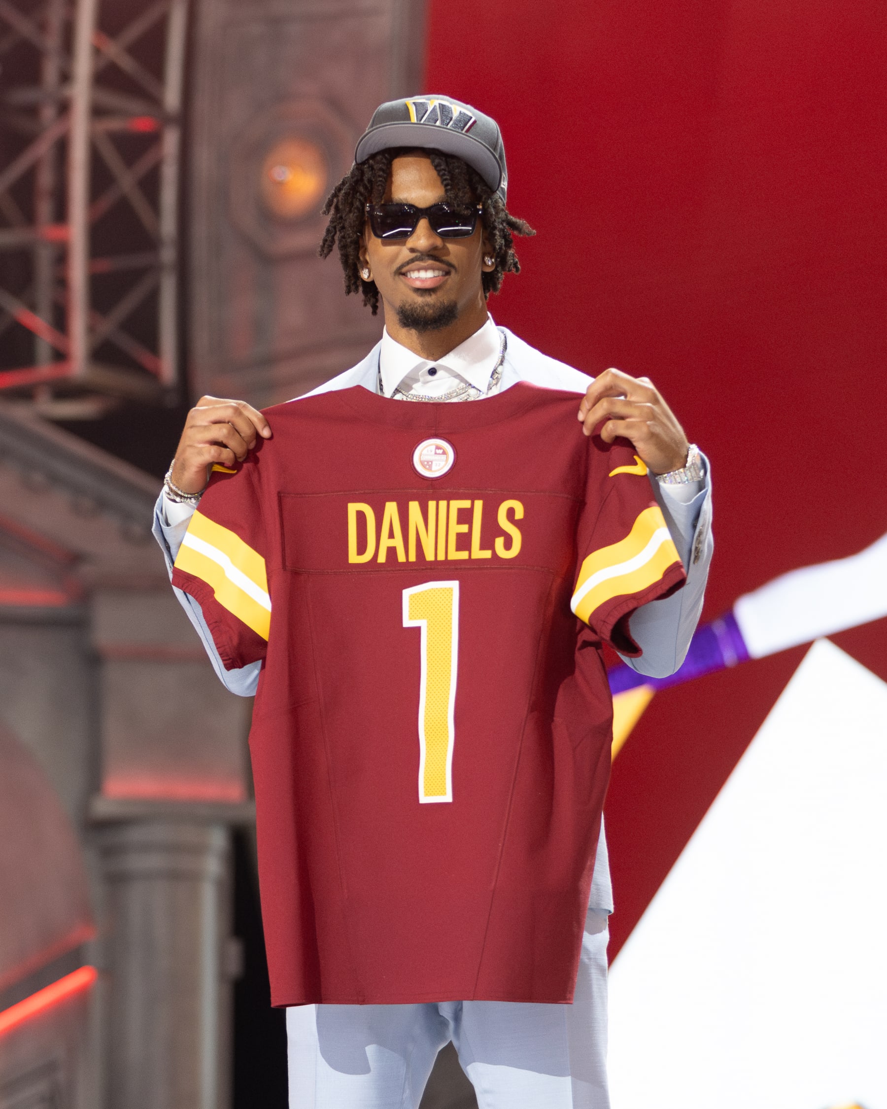 DETROIT, MI - APRIL 25: Washington Commanders Quarterback Jayden Daniels poses with a jersey after being picked second overall during day 1 of the NFL Draft on April 25, 2024 at Fox Theatre in Detroit, MI. (Photo by John Smolek/Icon Sportswire via Getty Images)