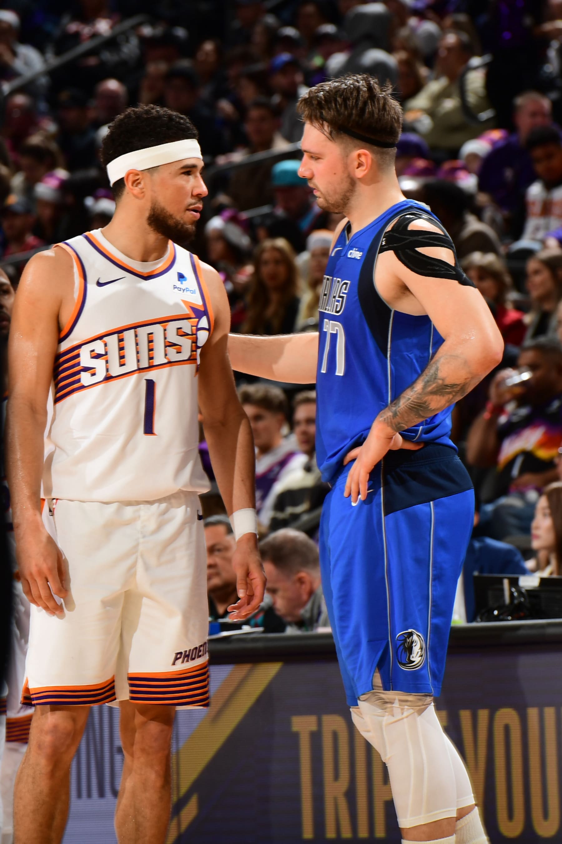 PHOENIX, AZ - DECEMBER 25: Luka Doncic #77 of the Dallas Mavericks talks with Devin Booker #1 of the Phoenix Suns during the game on December 25, 2023 at Footprint Center in Phoenix, Arizona. NOTE TO USER: User expressly acknowledges and agrees that, by downloading and or using this photograph, user is consenting to the terms and conditions of the Getty Images License Agreement. Mandatory Copyright Notice: Copyright 2023 NBAE (Photo by Kate Frese/NBAE via Getty Images)