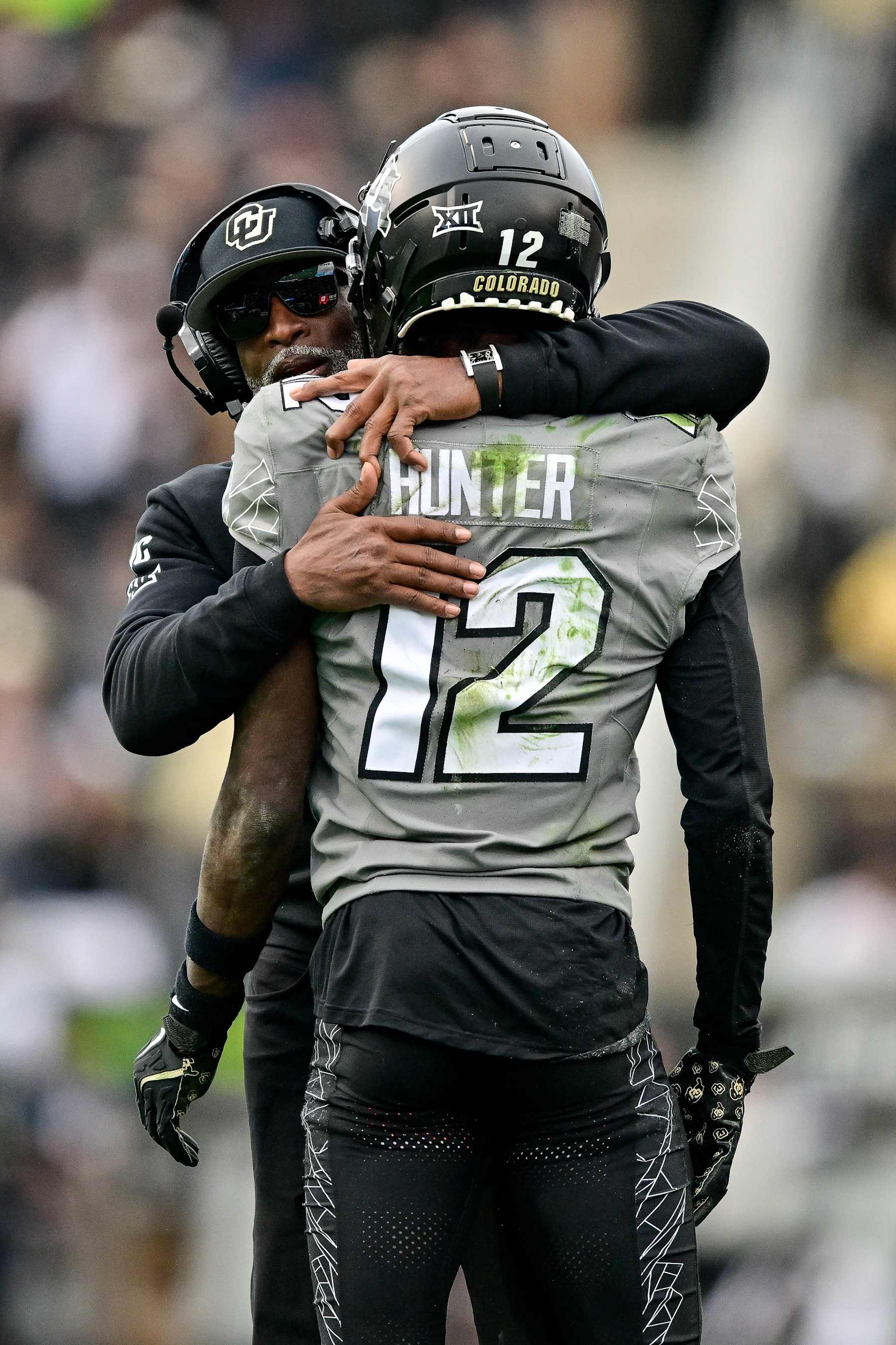 BOULDER, CO - NOVEMBER 16:  Travis Hunter #12 of the Colorado Buffaloes celebrates with head coach Deion Sanders after scoring a fourth quarter touchdown against the Utah Utes at Folsom Field on November 16, 2024 in Boulder, Colorado. (Photo by Dustin Bradford/Getty Images)