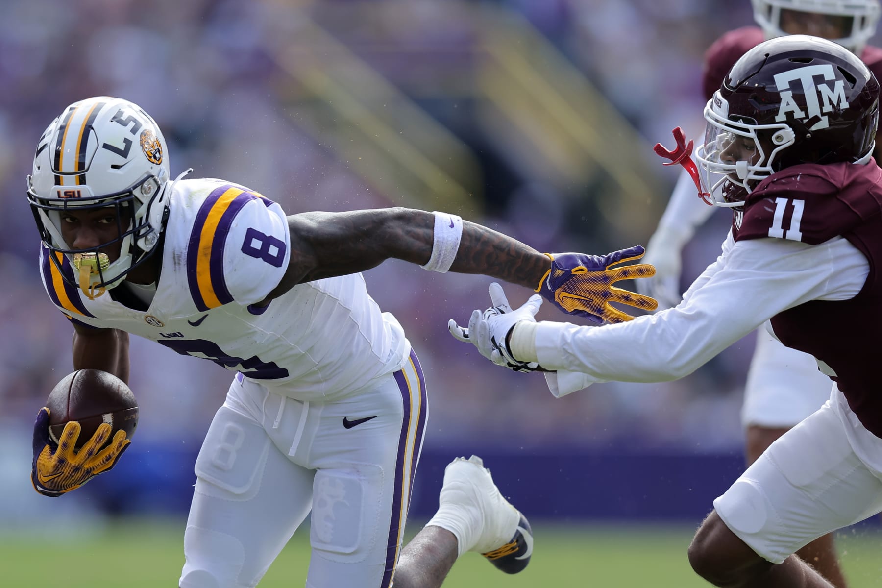BATON ROUGE, LOUISIANA - NOVEMBER 25: Malik Nabers #8 of the LSU Tigers runs with the ball as Deuce Harmon #11 of the Texas A&M Aggies defends during the first half at Tiger Stadium on November 25, 2023 in Baton Rouge, Louisiana. (Photo by Jonathan Bachman/Getty Images)