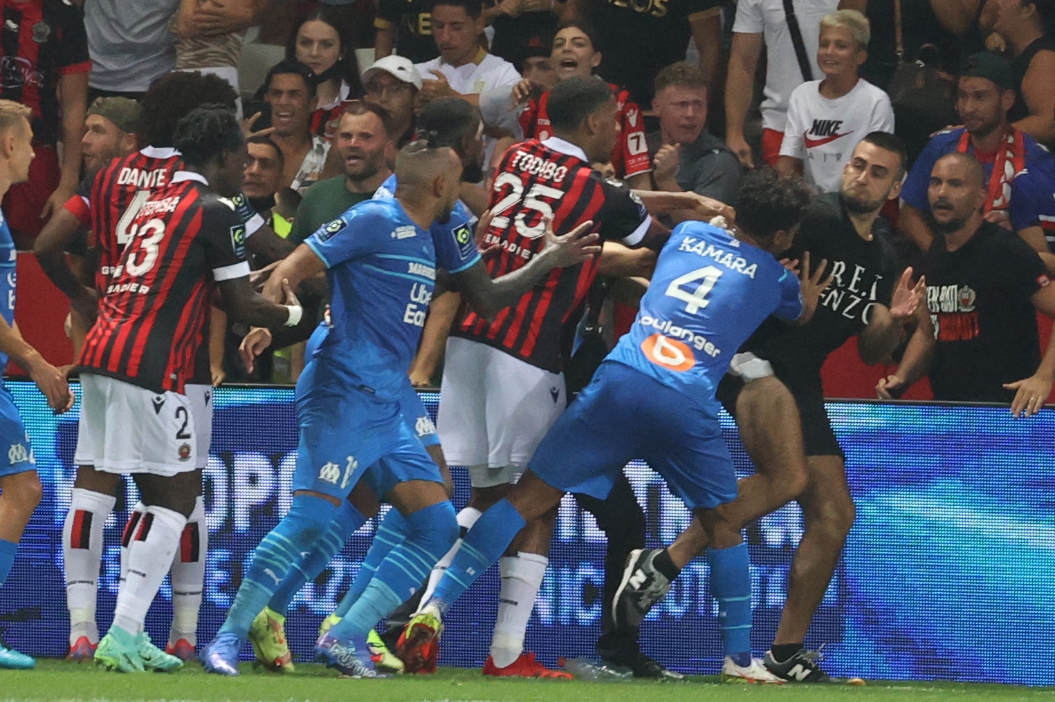 Fans try to invade the pitch during the French L1 football match between OGC Nice and Olympique de Marseille (OM) at the Allianz Riviera stadium in Nice, southern France on August 22, 2021. - The French Ligue 1 game between Nice and Marseille was halted on August 22, 2021, when fans of the home side invaded the pitch and angrily confronted opposing player Dimitri Payet. An AFP journalist at the game said trouble flared in the 75th minute when Marseille star Payet, who had been targeted by plastic bottles every time he took a corner, lobbed one back into the stands. (Photo by Valery HACHE / AFP) (Photo by VALERY HACHE/AFP via Getty Images)