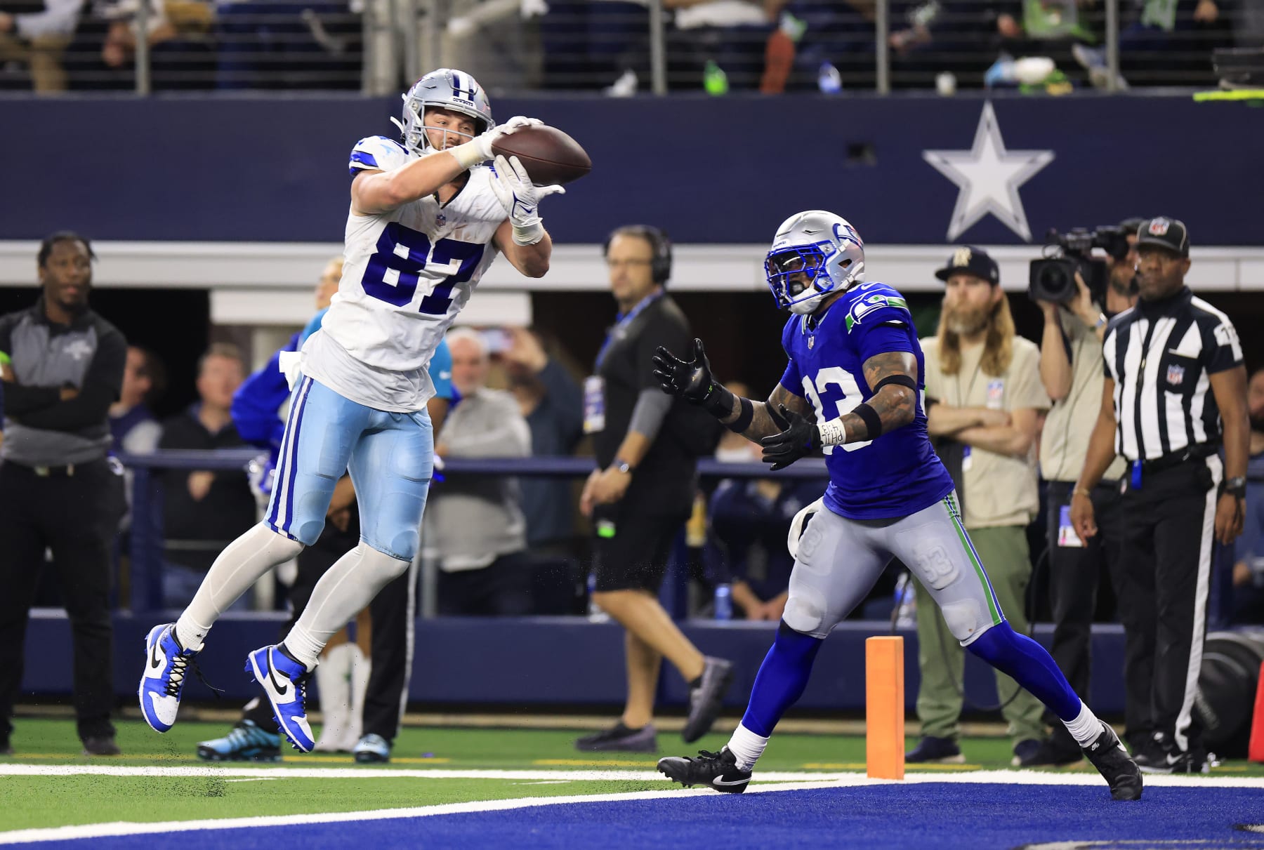 ARLINGTON, TEXAS - NOVEMBER 30:  Tight end Jake Ferguson #87 of the Dallas Cowboys makes a catch in the end-zone as safety Jamal Adams #33 of the Seattle Seahawks defends during the 4th quarter of the game at AT&T Stadium on November 30, 2023 in Arlington, Texas. (Photo by Ron Jenkins/Getty Images)