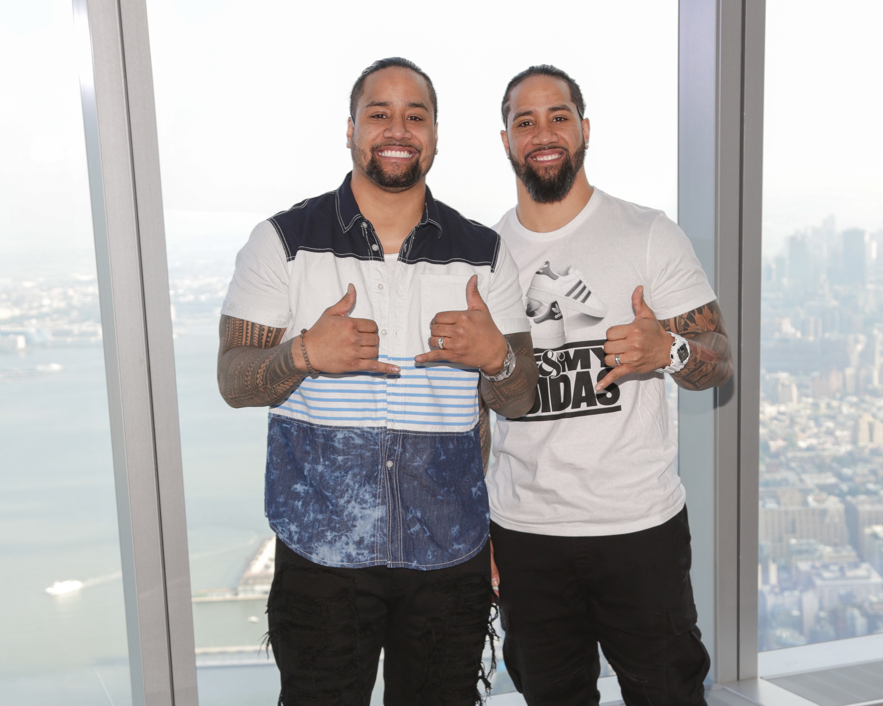 NEW YORK, NY - AUGUST 20:  WWE superstar Jimmy Uso (L) and WWE Hall of Famer Jey Uso pose for photographs during their visit to One World Observatory in advance of SummerSlam on August 20, 2016 in New York City.  (Photo by Brent N. Clarke/Getty Images)