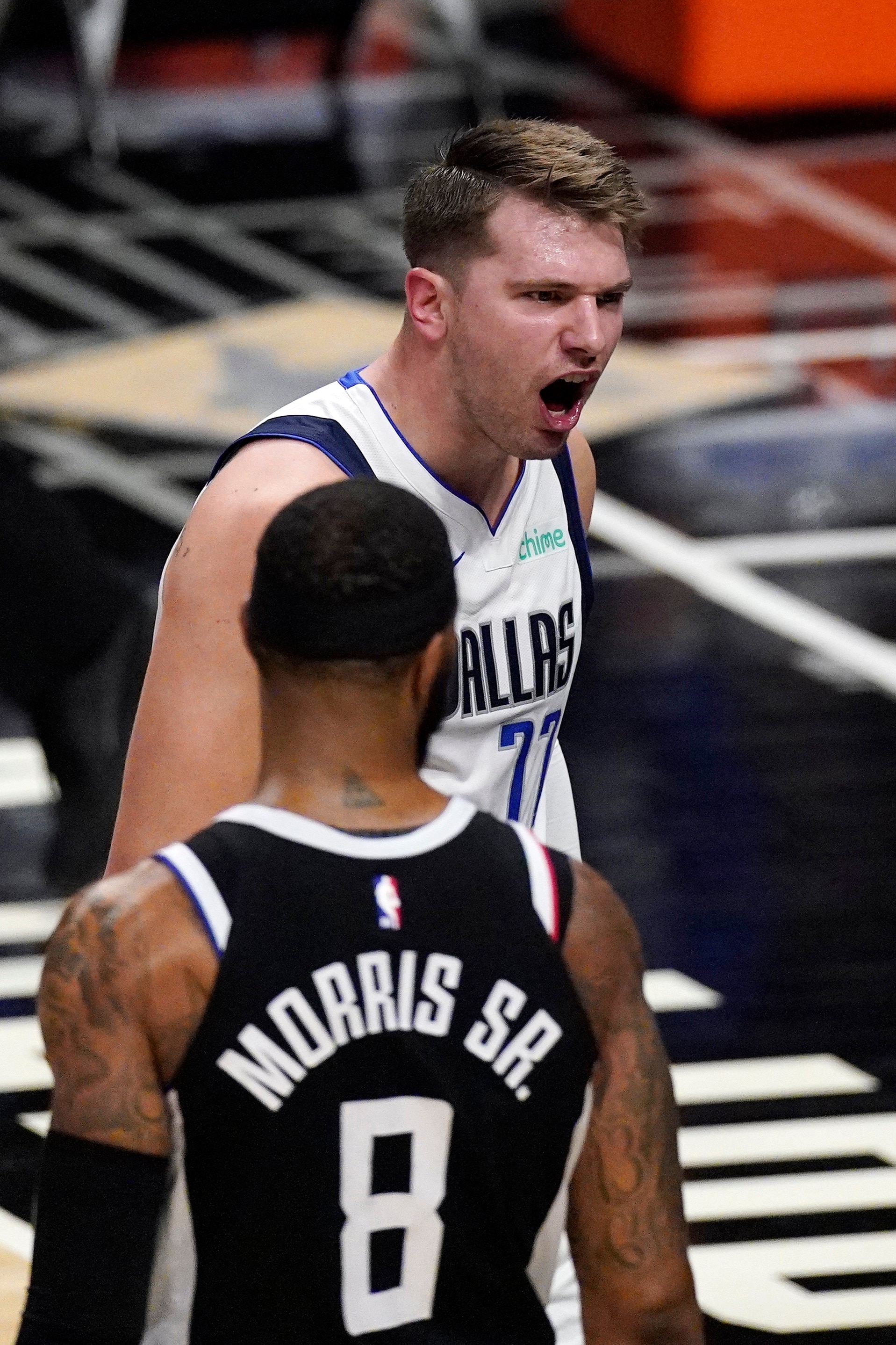 Dallas Mavericks guard Luka Doncic, top, celebrates after scoring as Los Angeles Clippers forward Marcus Morris Sr. looks on during the first half in Game 1 of an NBA basketball first-round playoff series Saturday, May 22, 2021, in Los Angeles. (AP Photo/Mark J. Terrill)