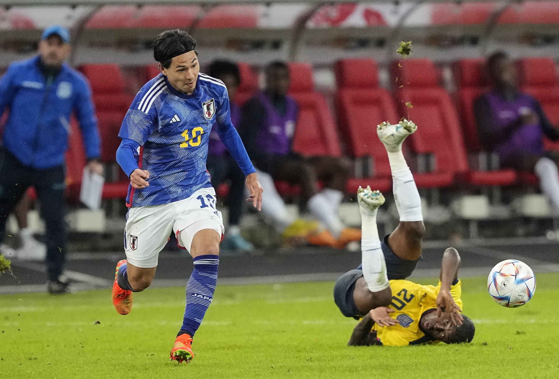 Japan's Takummi Minamino, left, and Ecuador's Jhegson Mendez challenge for the ball during the international friendly soccer match between Japan and Ecuador as part of the Kirin Challenge Cup in Duesseldorf, Germany, Tuesday, Sept. 27, 2022. (AP Photo/Martin Meissner)