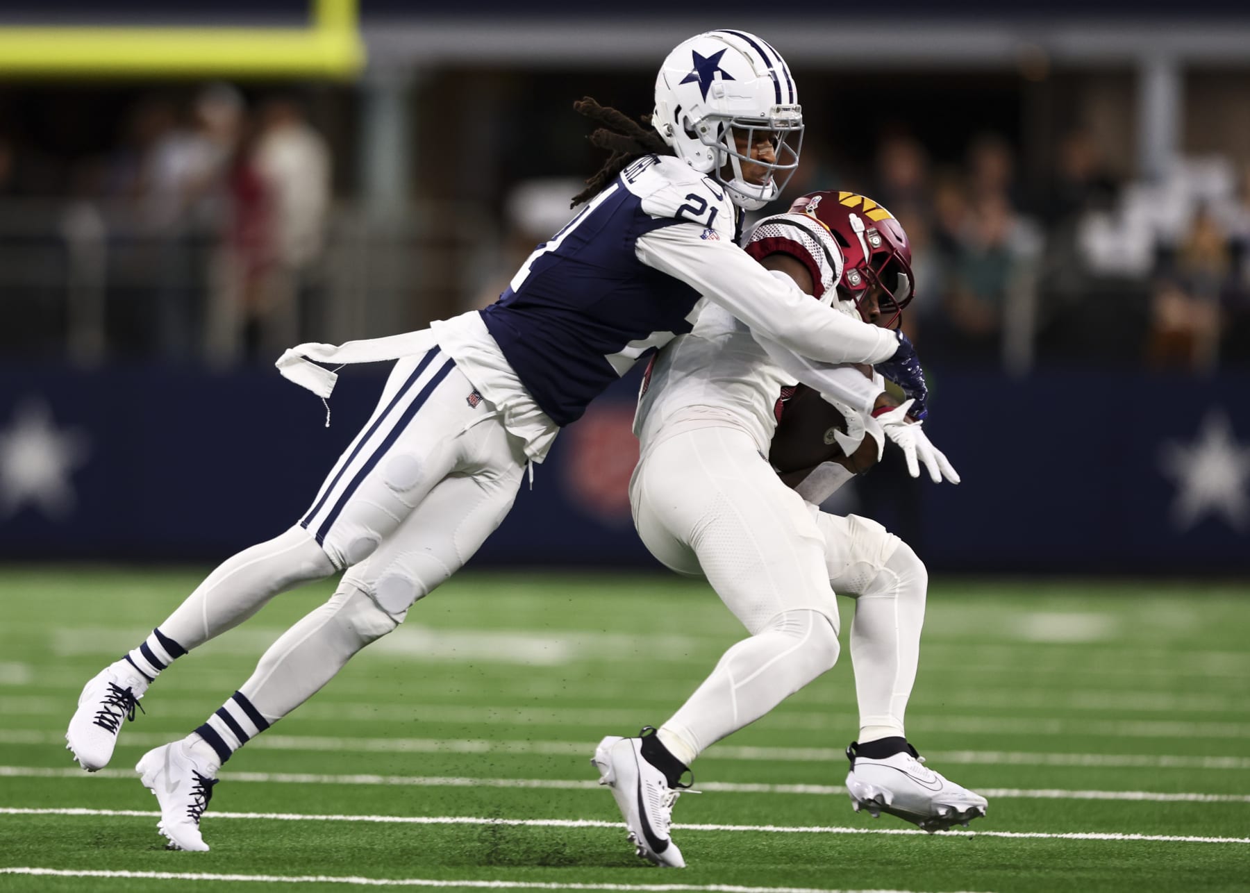 ARLINGTON, TX - NOVEMBER 23: Stephon Gilmore #21 of the Dallas Cowboys tackles Curtis Samuel #4 of the Washington Commanders during an NFL football game at AT&T Stadium on November 23, 2023 in Arlington, Texas. (Photo by Kevin Sabitus/Getty Images)