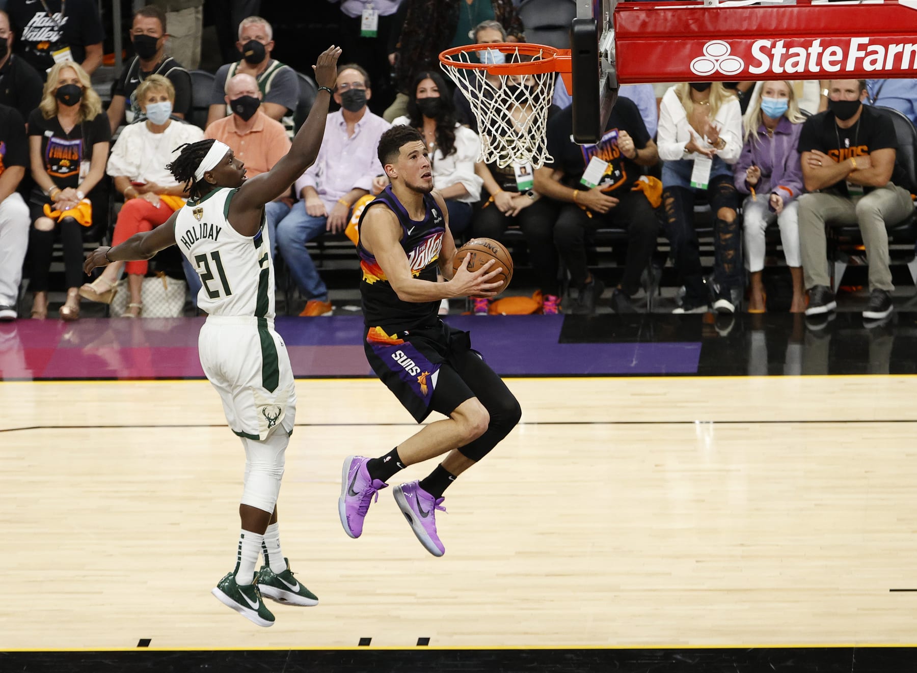 PHOENIX, ARIZONA - JULY 17: Devin Booker #1 of the Phoenix Suns goes up for a shot  against Jrue Holiday #21 of the Milwaukee Bucks during the second half in Game Five of the NBA Finals at Footprint Center on July 17, 2021 in Phoenix, Arizona. NOTE TO USER: User expressly acknowledges and agrees that, by downloading and or using this photograph, User is consenting to the terms and conditions of the Getty Images License Agreement.  (Photo by Christian Petersen/Getty Images)