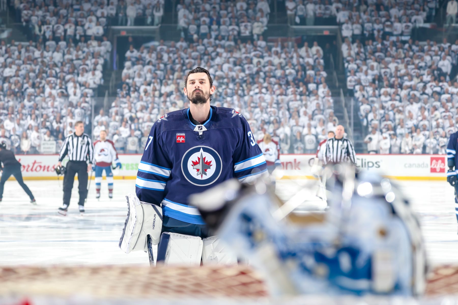 WINNIPEG, CANADA - APRIL 23: Goaltender Connor Hellebuyck #37 of the Winnipeg Jets looks on during the singing of the National anthems prior to puck drop against the Colorado Avalanche in Game Two of the First Round of the 2024 Stanley Cup Playoffs at the Canada Life Centre on April 23, 2024 in Winnipeg, Manitoba, Canada. (Photo by Jonathan Kozub/NHLI via Getty Images)