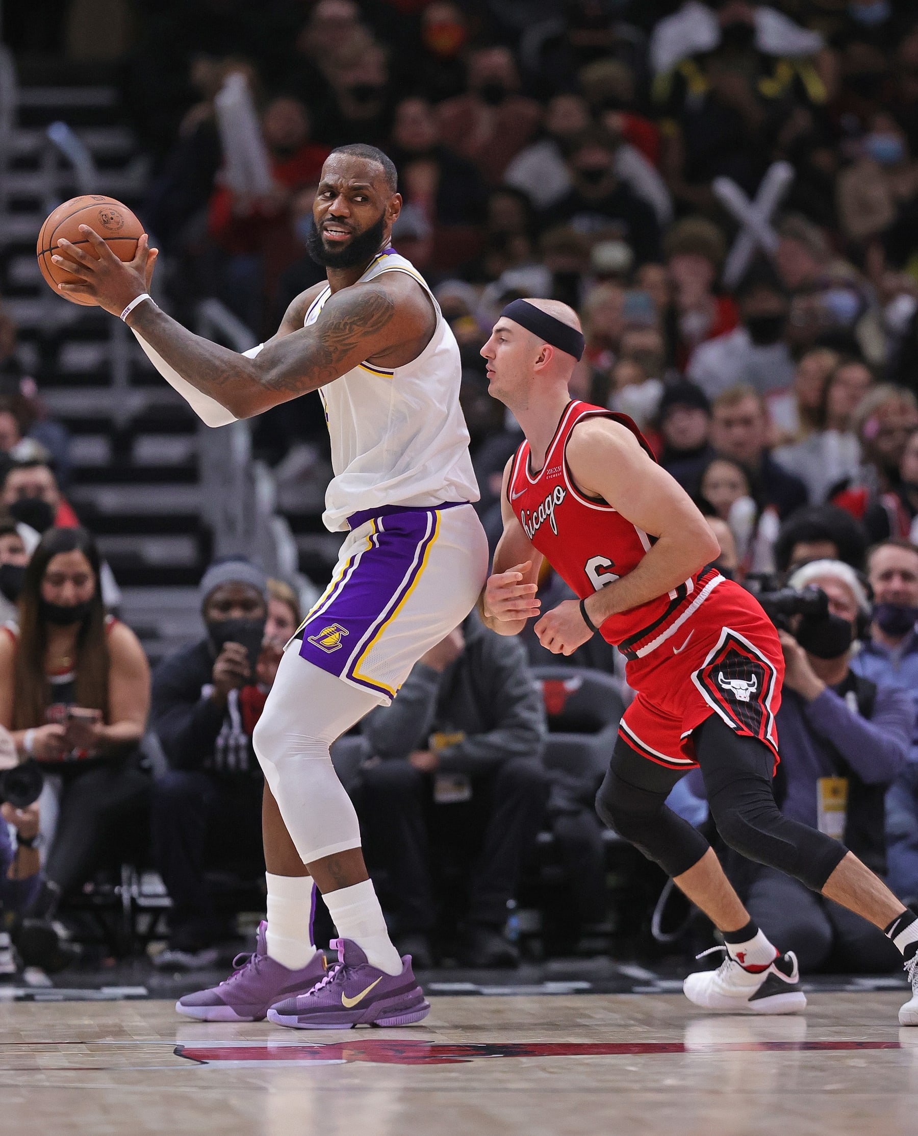 CHICAGO, ILLINOIS - DECEMBER 19: LeBron James #6 of the Los Angeles Lakers moves against Alex Caruso #6 of the Chicago Bulls at the United Center on December 19, 2021 in Chicago, Illinois. The Bulls defeated the Lakers 115-110. NOTE TO USER: User expressly acknowledges and agrees that, by downloading and or using this photograph, User is consenting to the terms and conditions of the Getty Images License Agreement. (Photo by Jonathan Daniel/Getty Images)
