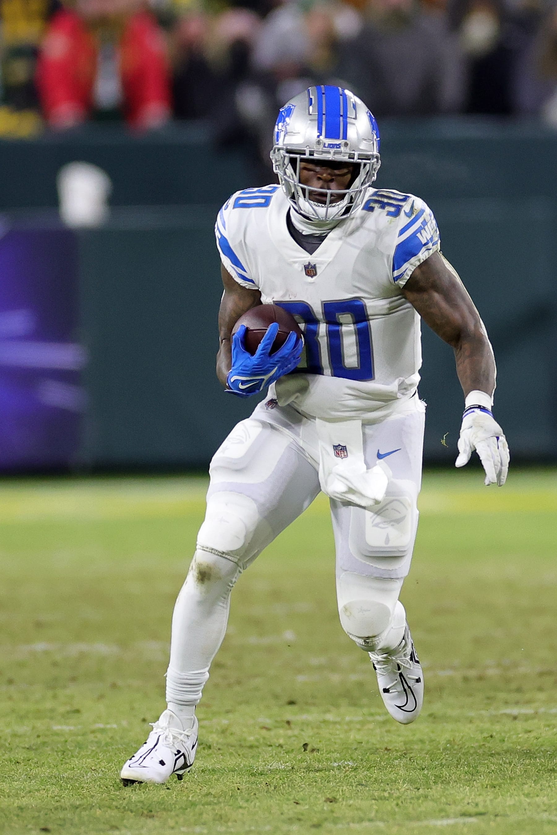 GREEN BAY, WISCONSIN - JANUARY 08: Jamaal Williams #30 of the Detroit Lions runs for yards during a game against the Green Bay Packers at Lambeau Field on January 08, 2023 in Green Bay, Wisconsin. The Lions defeated the Packers 20-16. (Photo by Stacy Revere/Getty Images)