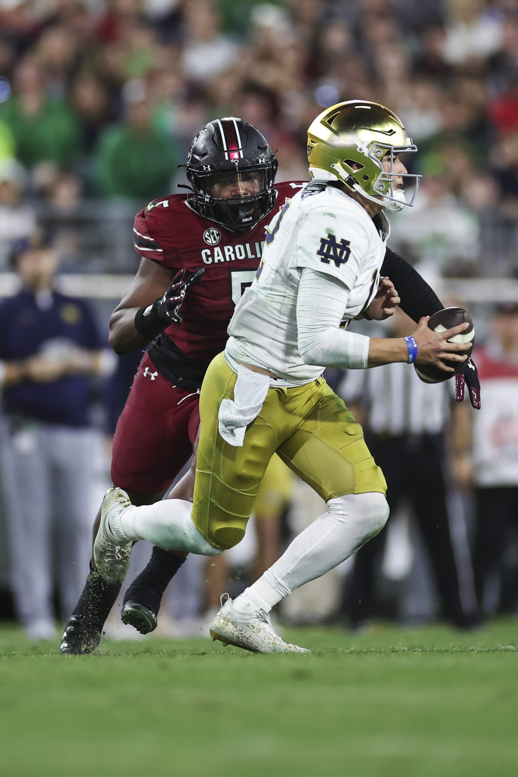 JACKSONVILLE, FLORIDA - DECEMBER 30: Tyler Buchner #12 of the Notre Dame Fighting Irish is pressured by Jordan Burch #5 of the South Carolina Gamecocks during the second half of the TaxSlayer Gator Bowl at TIAA Bank Field on December 30, 2022 in Jacksonville, Florida. (Photo by James Gilbert/Getty Images)