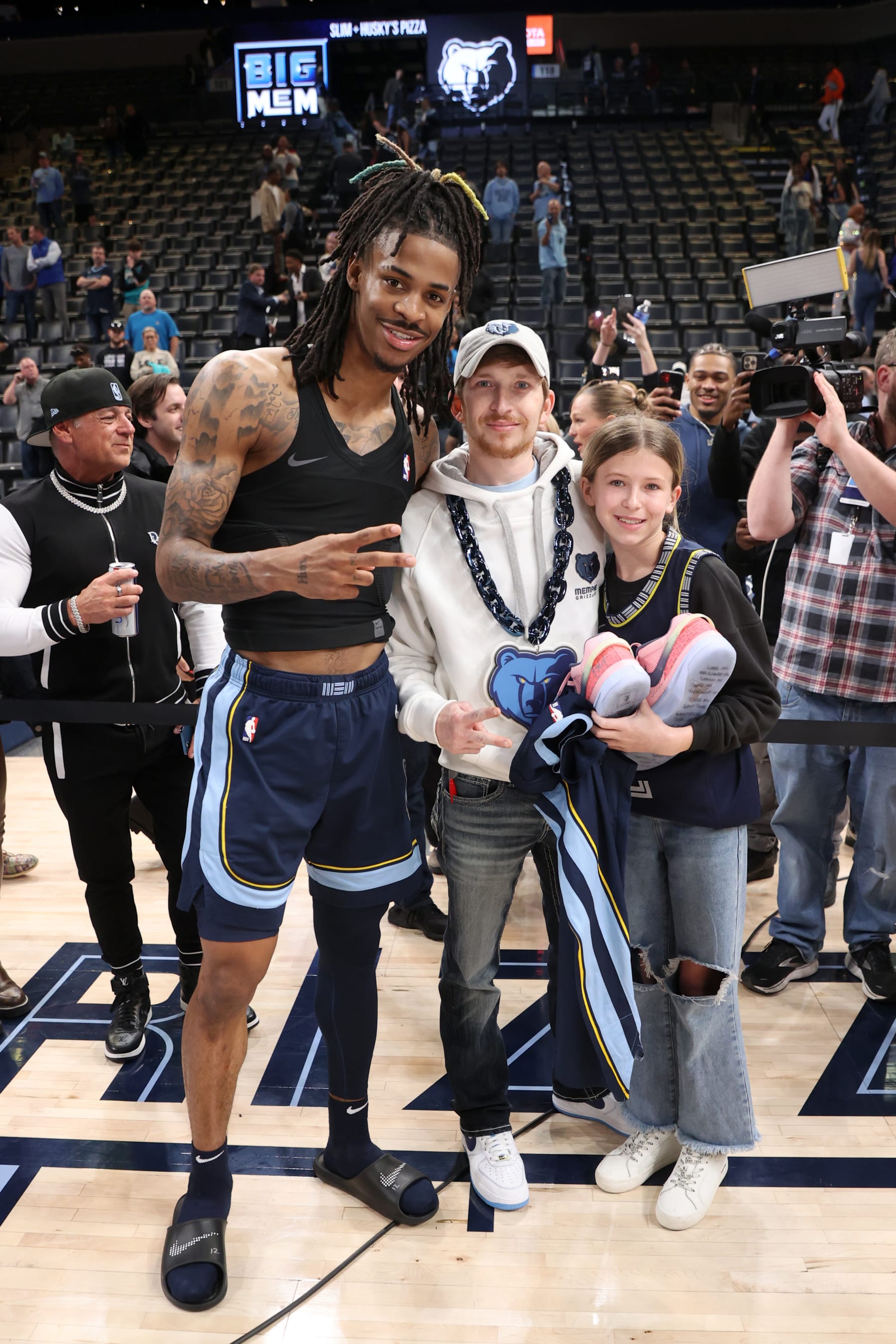 MEMPHIS, TN - JANUARY 11: Ja Morant #12 of the Memphis Grizzlies gifts his signed jersey and sneakers to fans after the game against the San Antonio Spurs on January 11, 2023 at FedExForum in Memphis, Tennessee. NOTE TO USER: User expressly acknowledges and agrees that, by downloading and or using this photograph, User is consenting to the terms and conditions of the Getty Images License Agreement. Mandatory Copyright Notice: Copyright 2023 NBAE (Photo by Joe Murphy/NBAE via Getty Images)