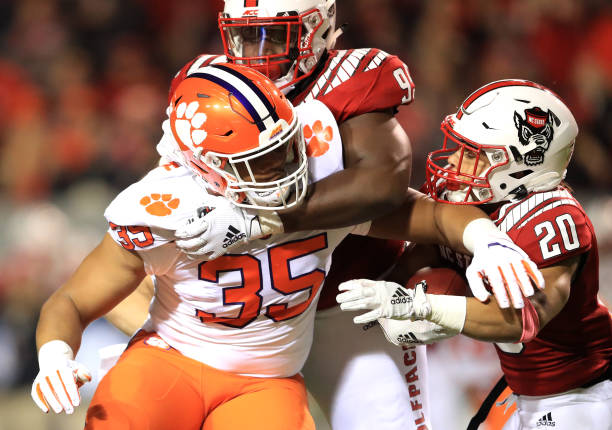 RALEIGH, NORTH CAROLINA - NOVEMBER 09: Jordan Houston #20 of the North Carolina State Wolfpack is hit by Justin Foster #35 of the Clemson Tigers during their game at Carter-Finley Stadium on November 09, 2019 in Raleigh, North Carolina. (Photo by Streeter Lecka/Getty Images)
