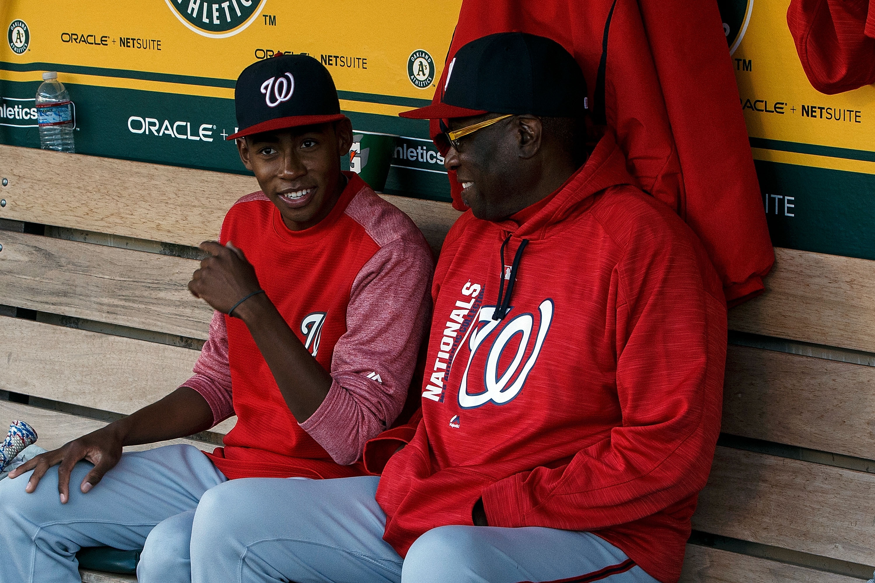 OAKLAND, CA - JUNE 02:  Dusty Baker #12 of the Washington Nationals sits with his son Darren Baker in the dugout before the game against the Oakland Athletics at the Oakland Coliseum on June 2, 2017 in Oakland, California. The Washington Nationals defeated the Oakland Athletics 13-3. (Photo by Jason O. Watson/Getty Images)