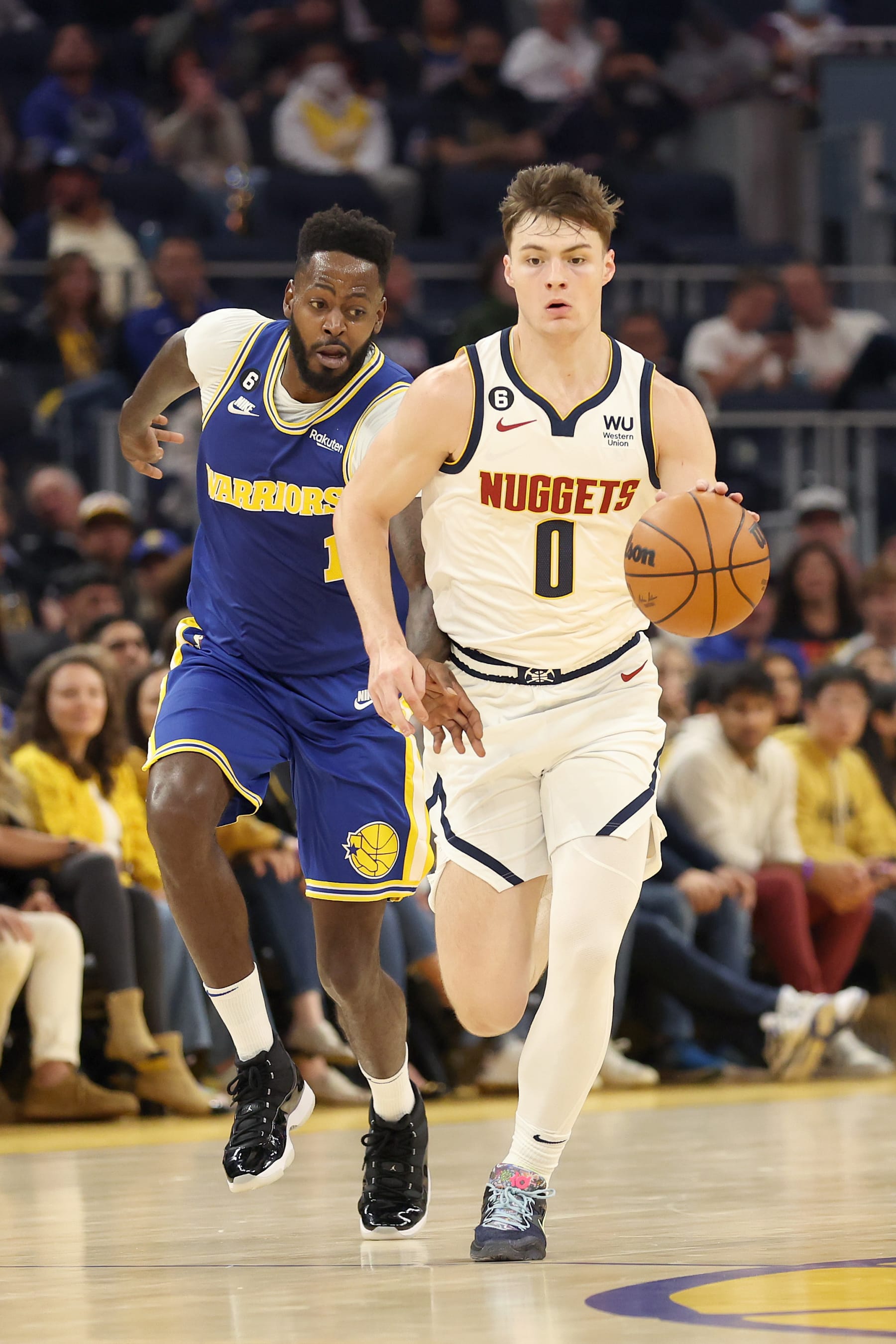 SAN FRANCISCO, CALIFORNIA - OCTOBER 21: Christian Braun #0 of the Denver Nuggets dribbles past JaMychal Green #1 of the Golden State Warriors at Chase Center on October 21, 2022 in San Francisco, California. NOTE TO USER: User expressly acknowledges and agrees that, by downloading and or using this photograph, User is consenting to the terms and conditions of the Getty Images License Agreement.  (Photo by Ezra Shaw/Getty Images)