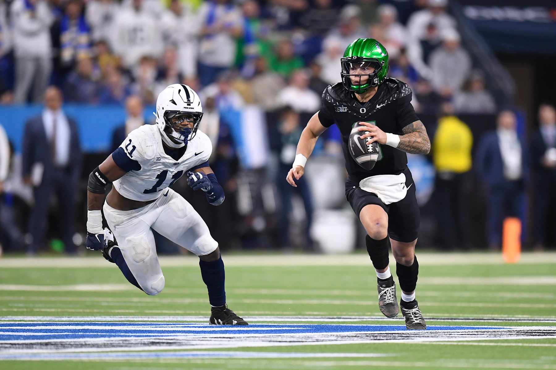 INDIANAPOLIS, IN - DECEMBER 07: Oregon Ducks Quarterback Dillon Gabriel (8) scrambles as Penn State Nittany Lions Defensive End Abdul Carter (11) defends during the Big Ten Championship football game between the Penn State Nittany Lions and the Oregon Ducks on December 7, 2024, at Lucas Oil Stadium in Indianapolis, Indiana. (Photo by Michael Allio/Icon Sportswire via Getty Images)