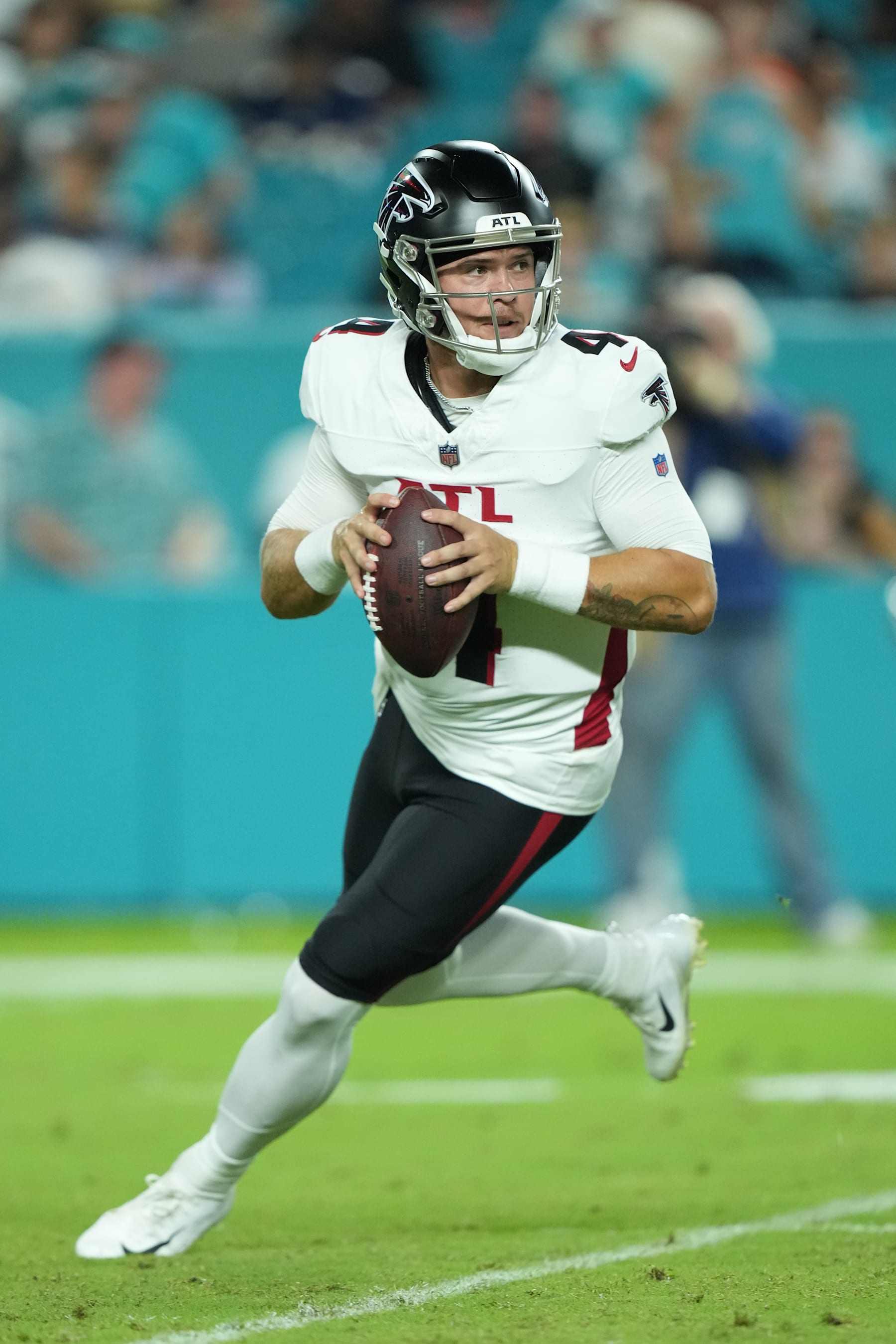 MIAMI GARDENS, FL - AUGUST 09: Atlanta Falcons quarterback Taylor Heinicke (4) looks for an open receiver as he rolls right in the first half during the game between the Atlanta Falcons and the Miami Dolphins on Friday, August 9, 2024 at Hard Rock Stadium in Miami Gardens, Fla.(Photo by Peter Joneleit/Icon Sportswire via Getty Images)