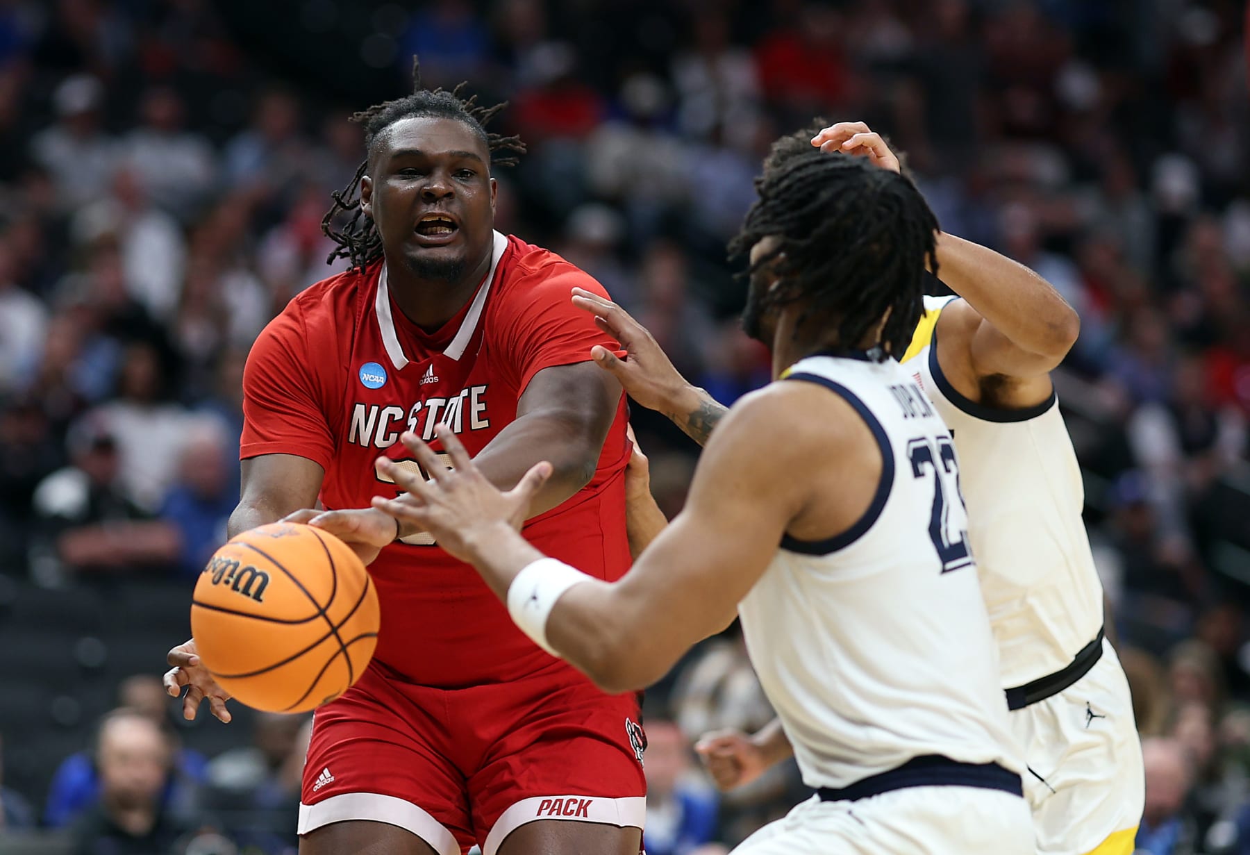DALLAS, TEXAS - MARCH 29: DJ Burns Jr. #30 of the North Carolina State Wolfpack controls the ball as David Joplin #23 of the Marquette Golden Eagles defends during the first half in the Sweet 16 round of the NCAA Men's Basketball Tournament at American Airlines Center on March 29, 2024 in Dallas, Texas. (Photo by Patrick Smith/Getty Images)