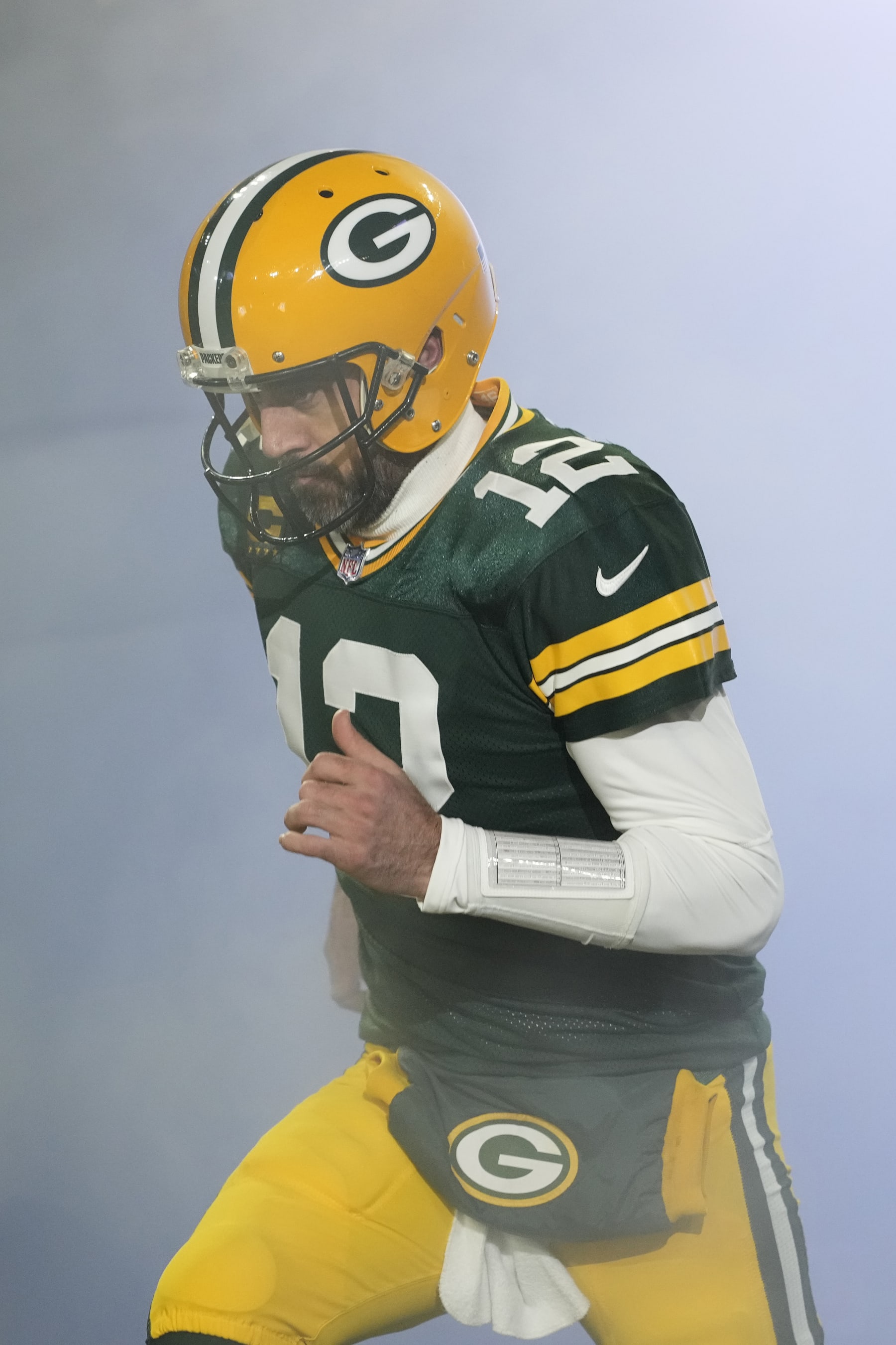 GREEN BAY, WISCONSIN - JANUARY 08: Aaron Rodgers #12 of the Green Bay Packers runs onto the field before a game against the Detroit Lions at Lambeau Field on January 08, 2023 in Green Bay, Wisconsin. (Photo by Patrick McDermott/Getty Images)
