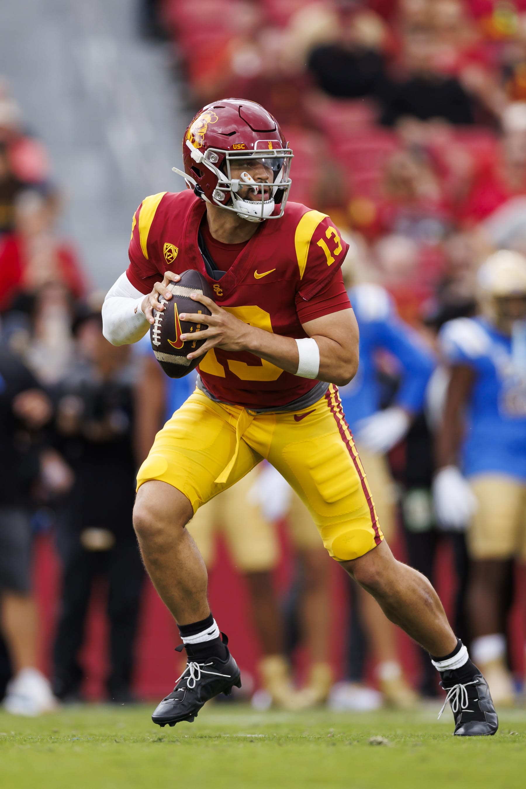 LOS ANGELES, CALIFORNIA - NOVEMBER 18: Caleb Williams #13 of the USC Trojans rolls out and looks to throw a pass during the first half of a game against the UCLA Bruins at United Airlines Field at the Los Angeles Memorial Coliseum on November 18, 2023 in Los Angeles, California. (Photo by Ryan Kang/Getty Images)